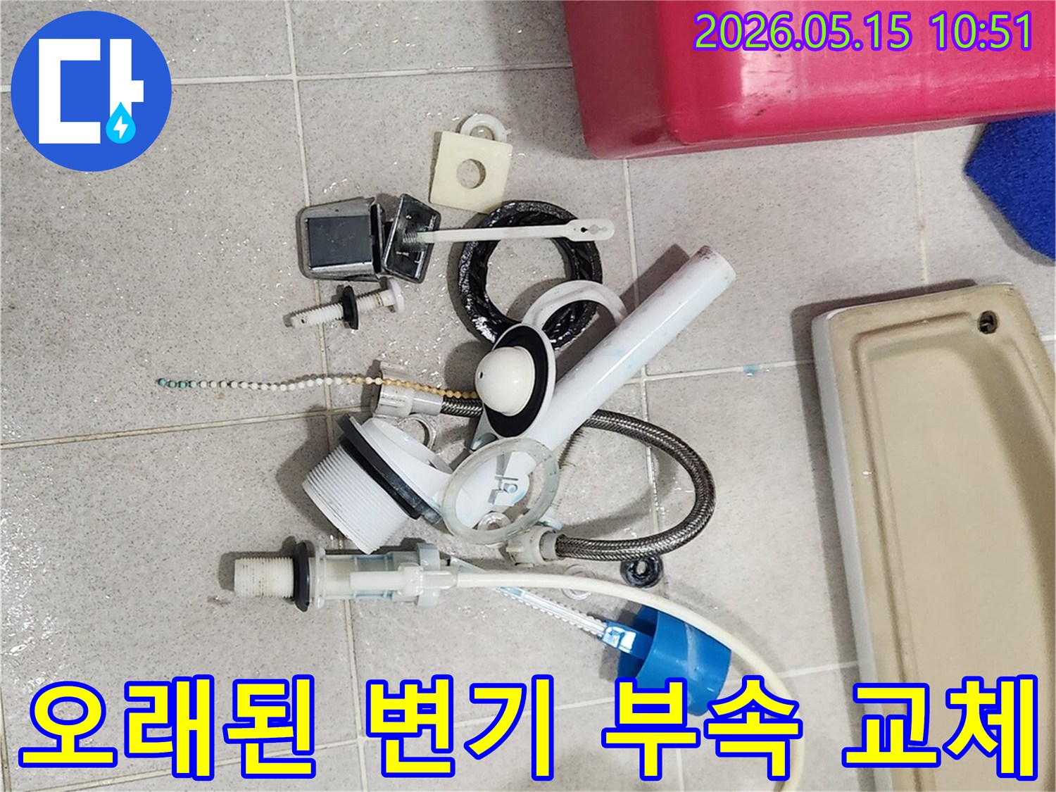 오랜 사용으로 낡아버린 변기 부속품들이-바닥에 놓여-새 부품으로 교체될 준비를 마쳤습니다