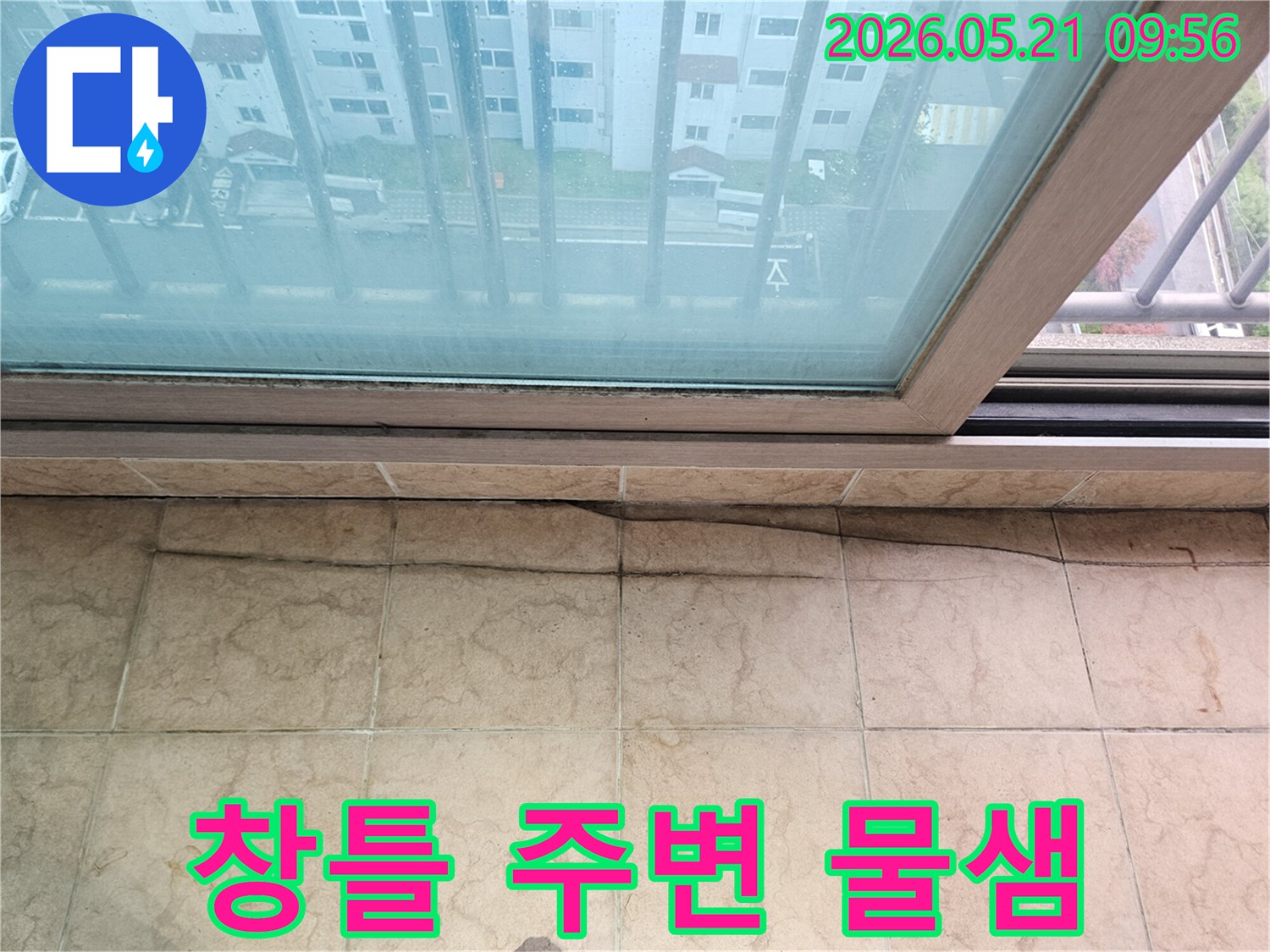 아파트 베란다 천장과-창틀-경계에서-물이-새어-나와-타일이-젖은-모습을-보여주는-사진