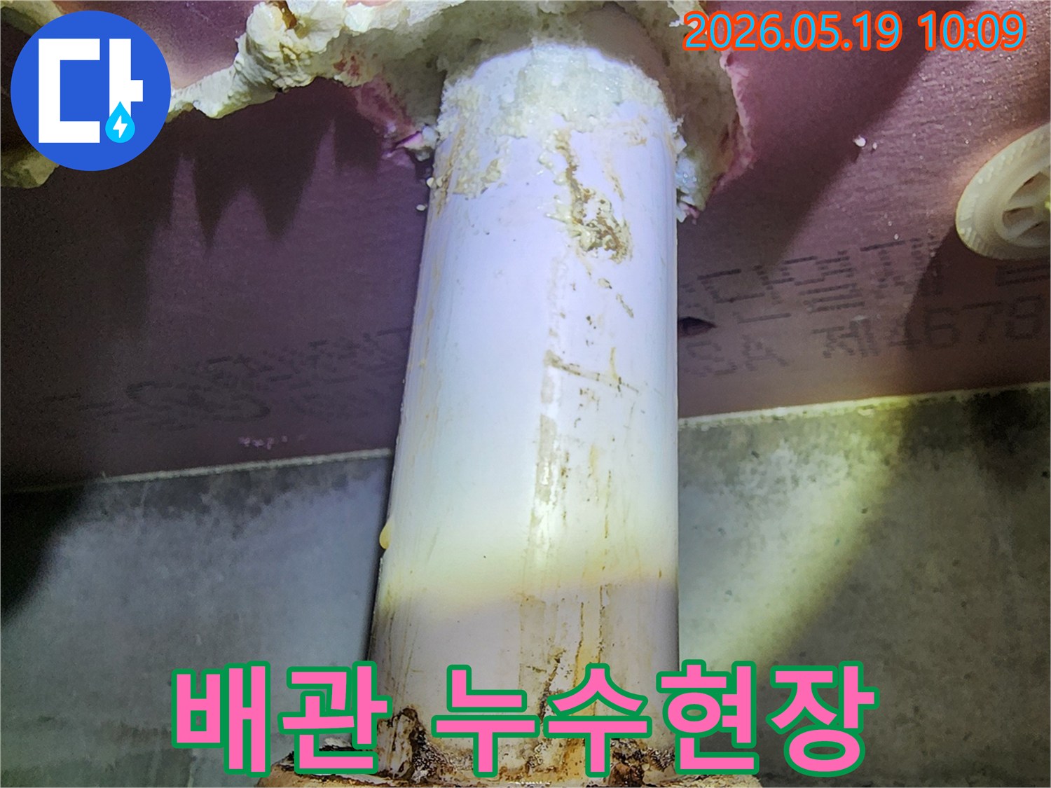 이 이미지는 배관에서 물이 새어 나와-주변 단열재를 적시고 있는-누수 현장의 모습을 담고 있습니다