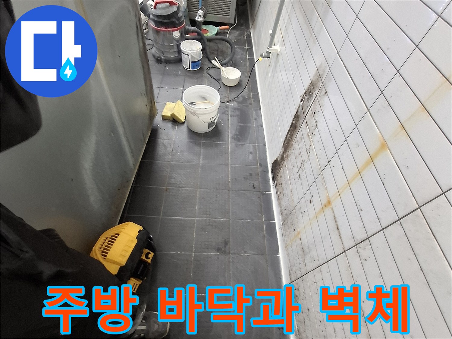상업용 주방의 어두운 타일 바닥과 하얀색 벽면의 경계 부위 점검 모습