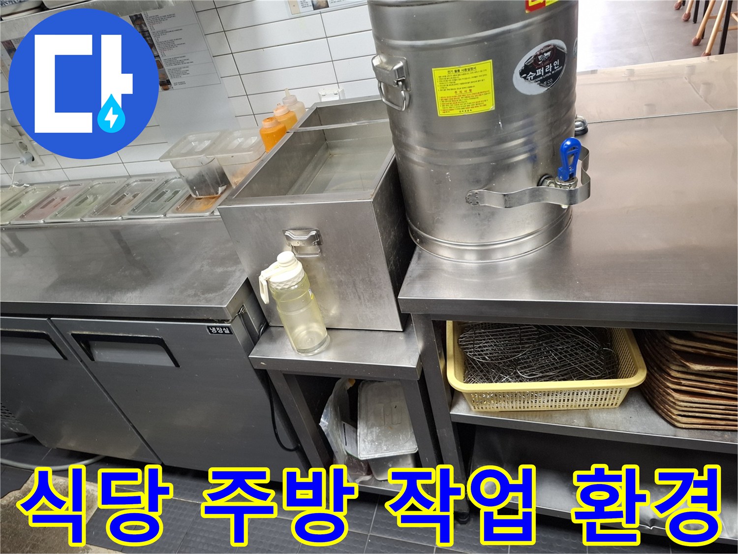 스테인리스 조리 시설과 배수구 트렌치가 있는 주방 내부입니다.