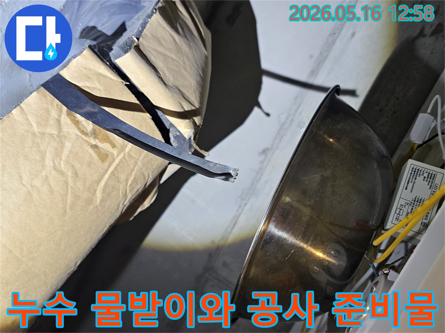 누수-지점에서-떨어지는-물을-안전하게-모으기-위해-설치된-금속-용기와-주변-공사-자재