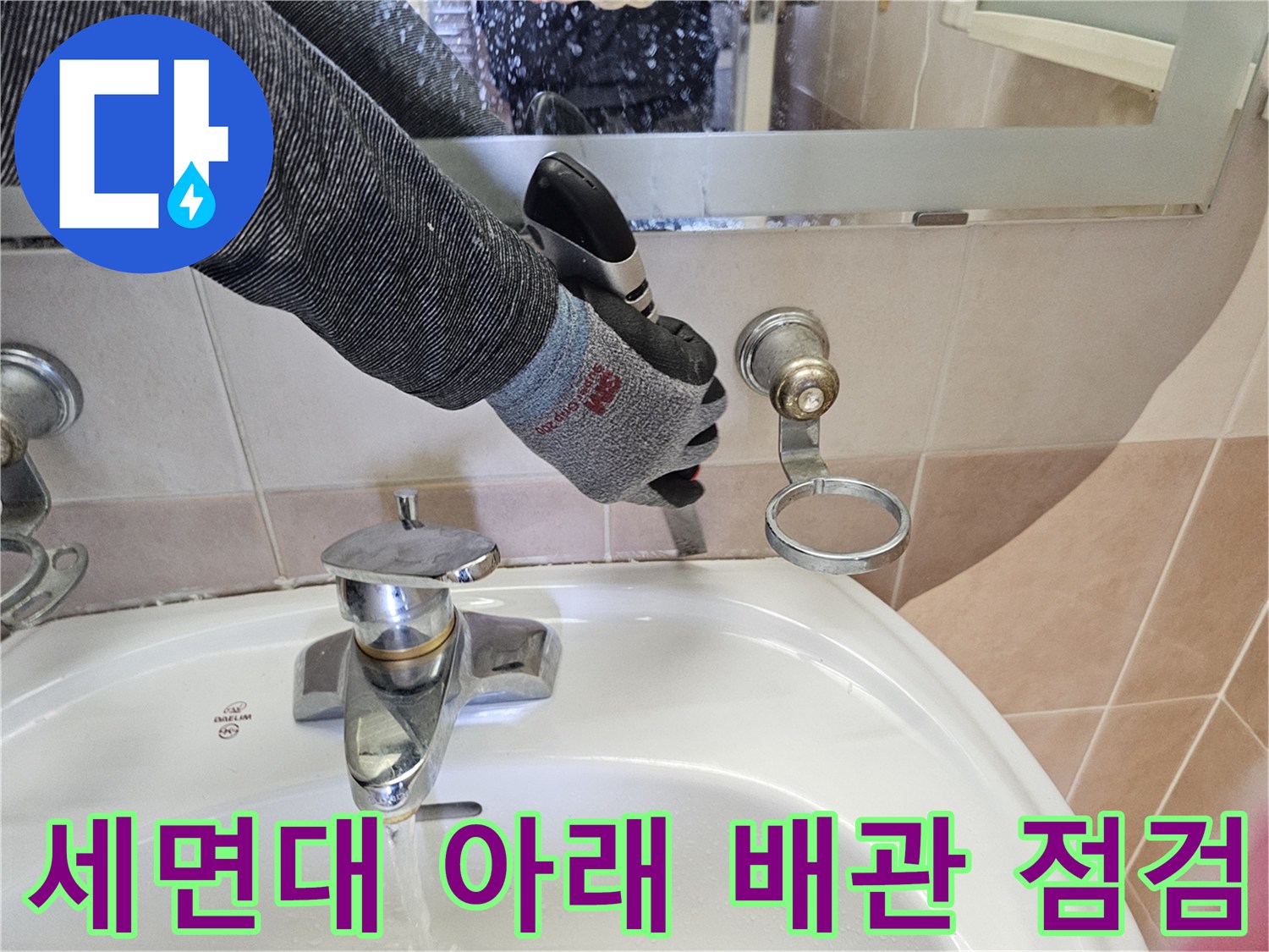 세면대 하단 수전 부위의 벽면 연결 상태를 엔지니어가 정밀하게 조사하고 있습니다.