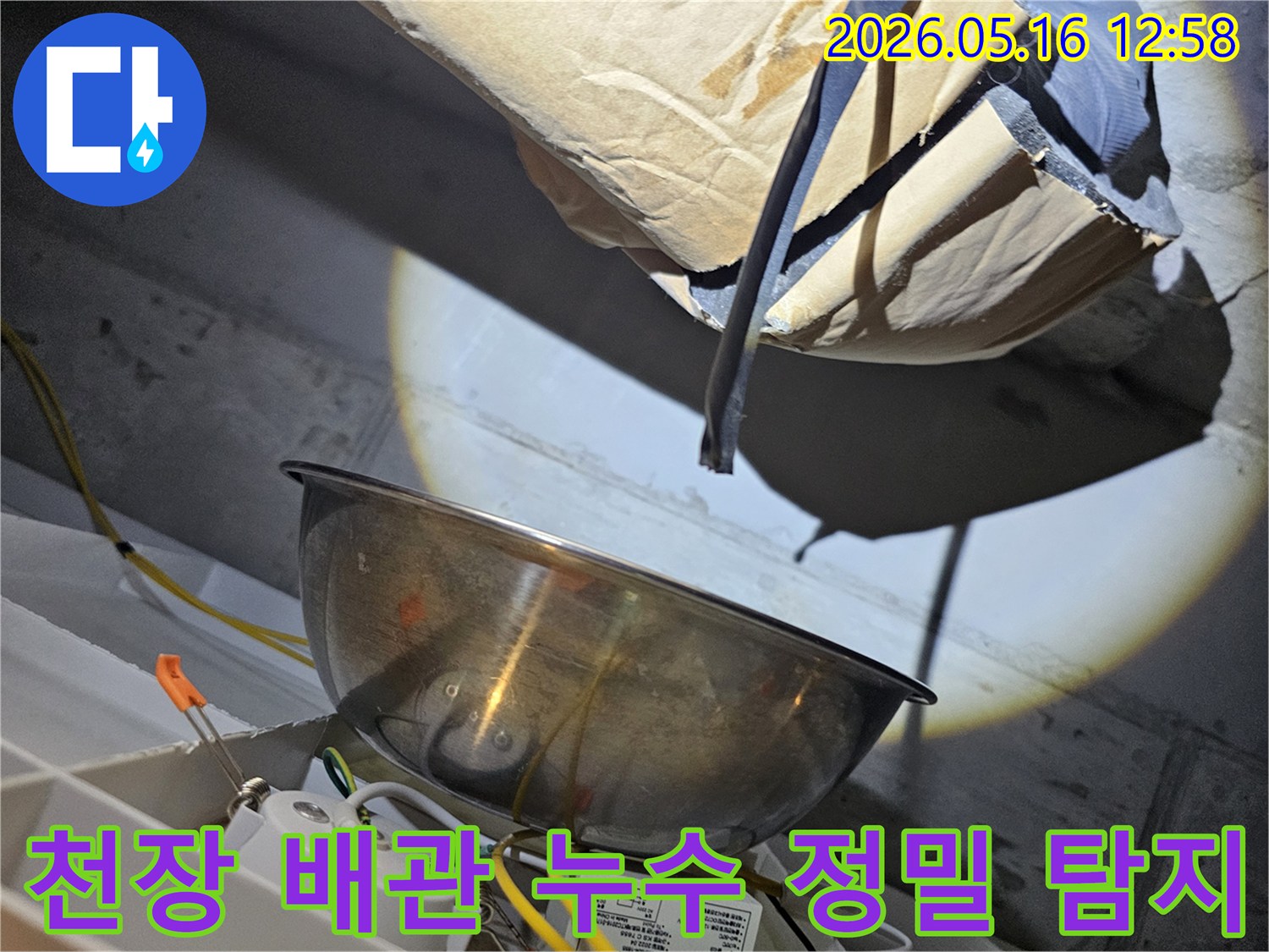 아파트 천장 내부에서-강력한 조명으로-배관의 미세한 누수 지점을-정밀하게 탐지하는-전문가의 모습입니다