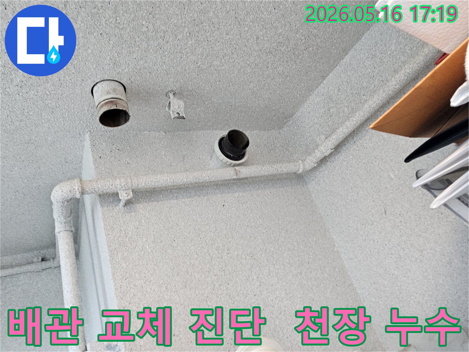 이 사진은-아파트 천장 내부의-배관 상태를-점검하며-누수 발생으로 인한-배관 교체의-필요성을-진단하는-엔지니어의-작업 현장입니다.