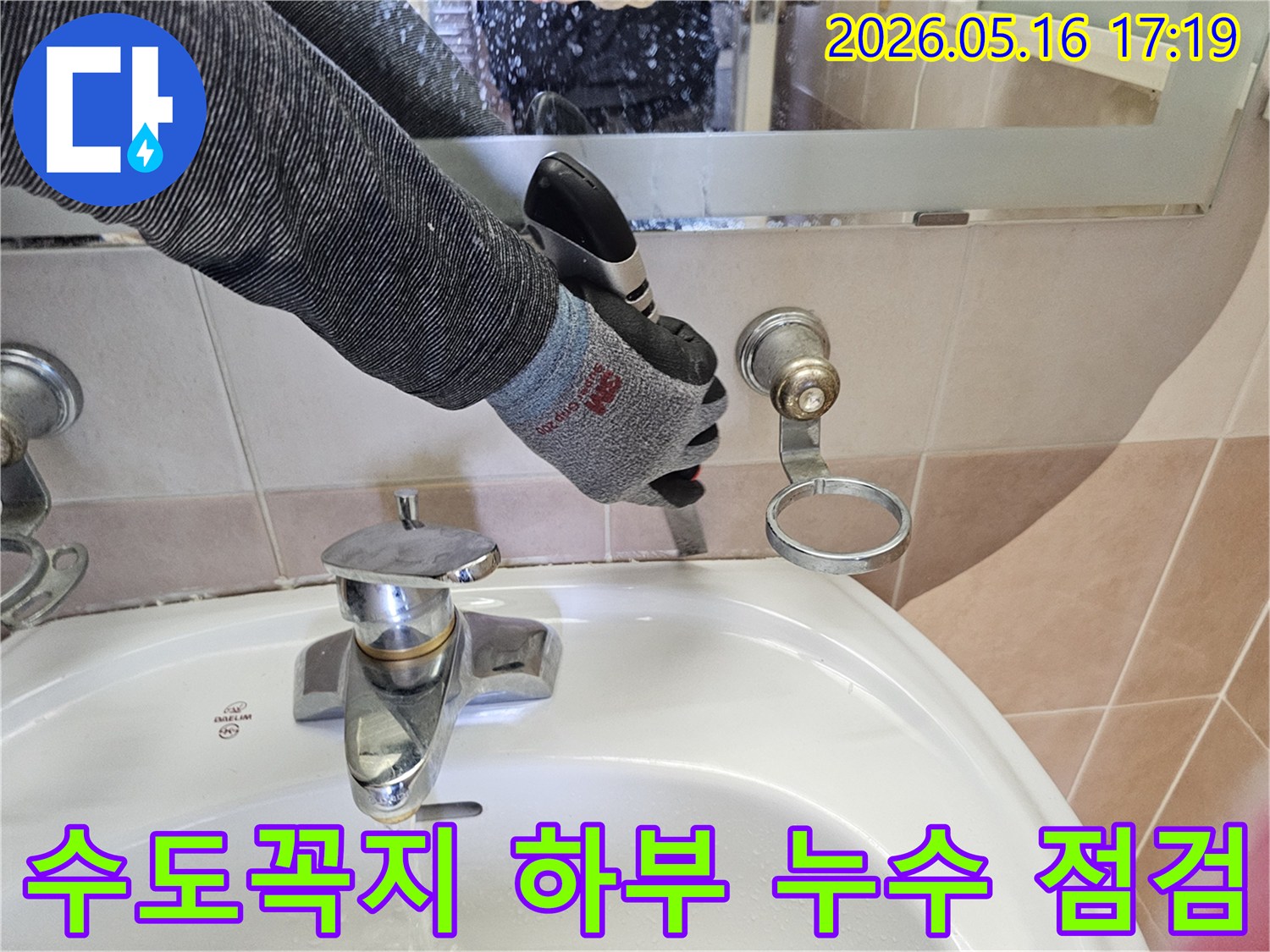 전문 엔지니어가-안전 장갑을 착용하고-욕실 세면대 수도꼭지 하부의-미세한 누수 지점을-세심하게 점검하고 있습니다.