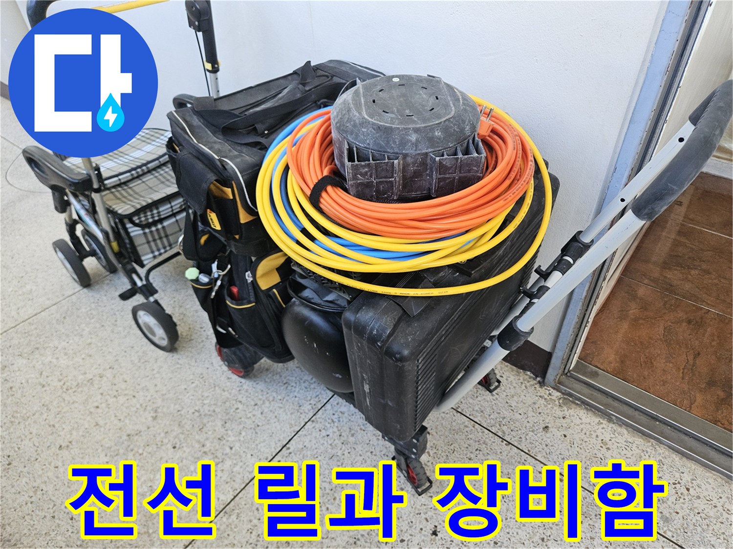 작업 현장에 배치된 노란색 전선 릴 및 검정 장비 케이스