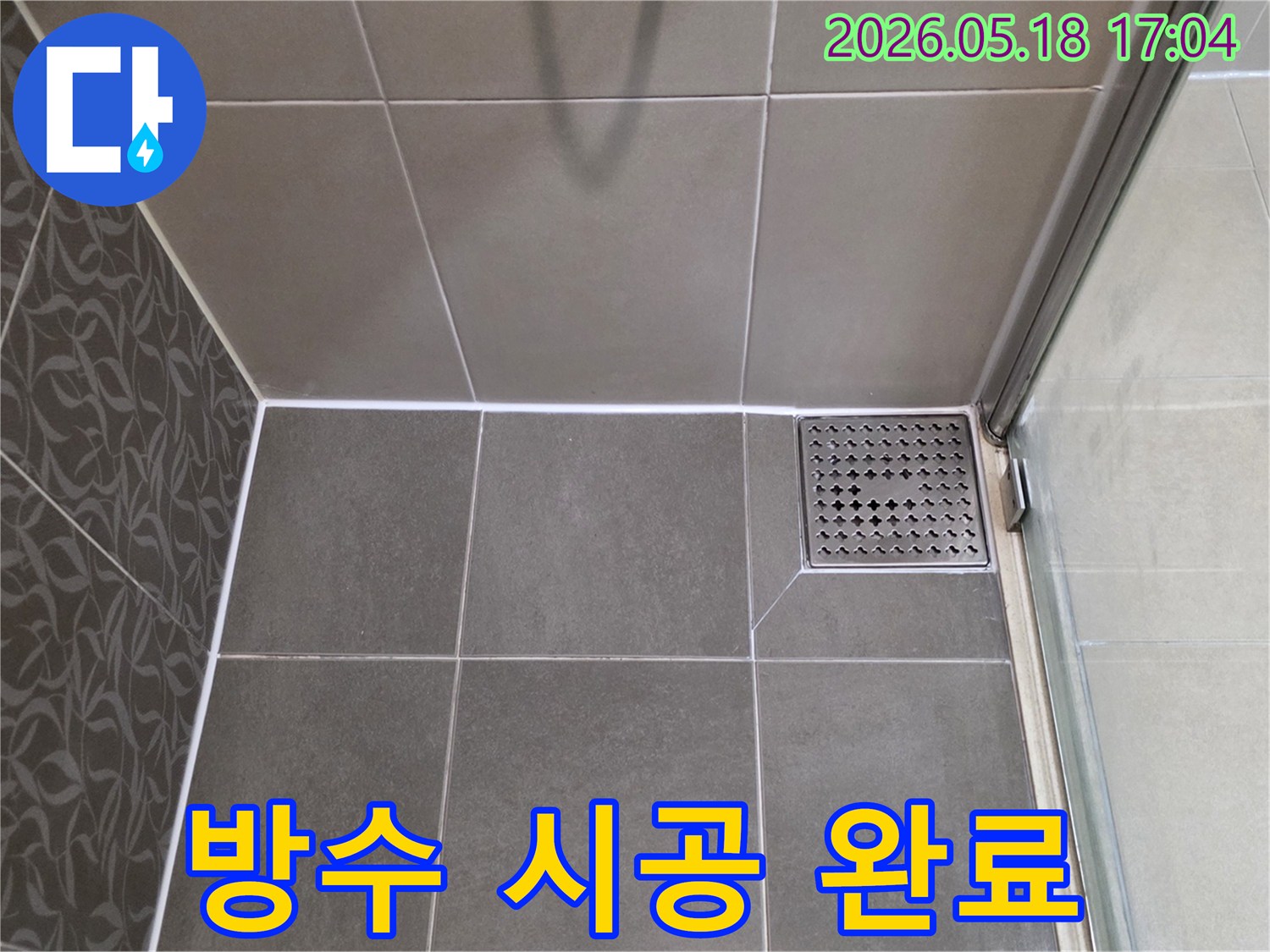 욕실 누수 문제 해결 후-배수구 주변의-완벽한 방수 마감과-새로운 줄눈 시공으로-깔끔해진-바닥을-보여주는 이미지입니다.