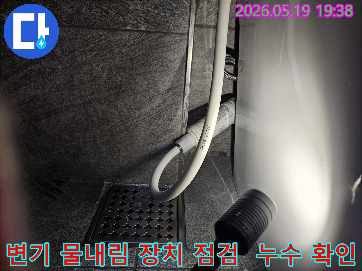 이 이미지는-용인 수지 아파트 화장실에서-변기 물내림 장치의 누수 여부를-플래시로 비추며-세밀하게 점검하는 현장을 보여줍니다.