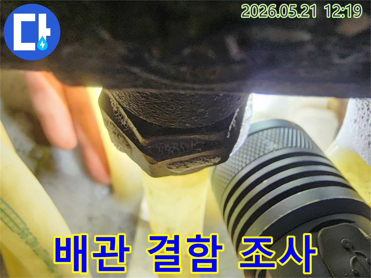 플래시를 이용해-어두운 배관 주변을-밝혀-배관 결함으로 인한-누수 흔적을-정밀하게 조사하는-전문가의 시선