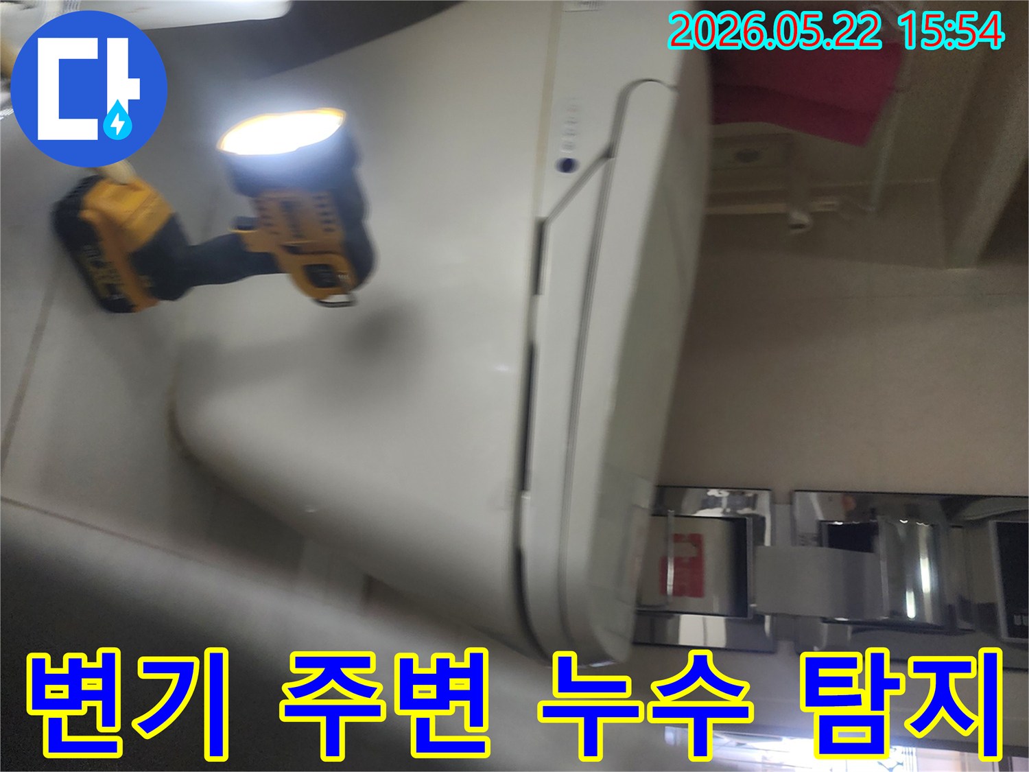 용인 보정동 욕실에서-변기 주변의 누수 여부를-확인하기 위해-작업등을 비추며-세심하게 탐지하는-누수 전문가의 현장 작업