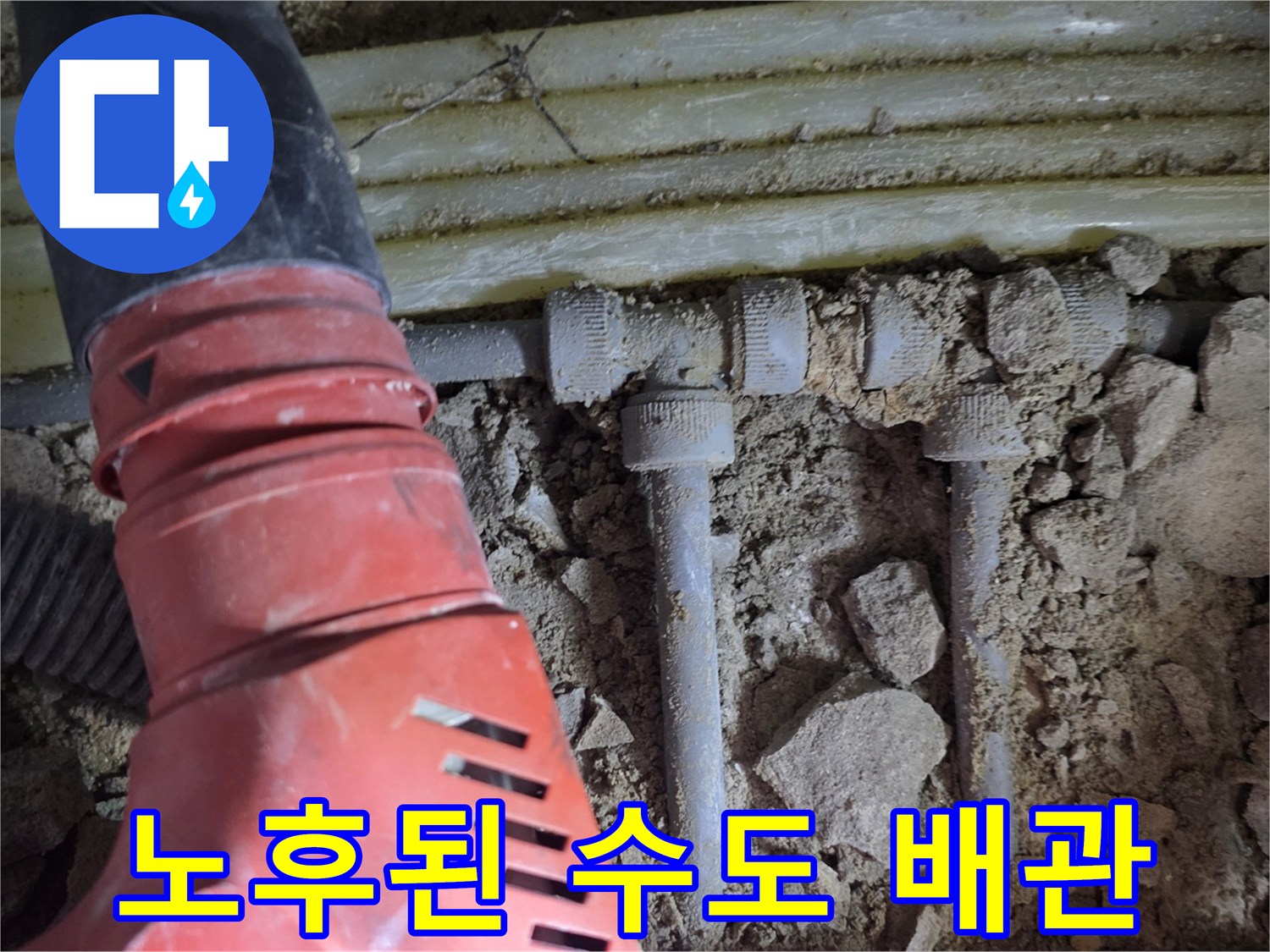 흙과 파편 사이로 노출된 금속 소재의 배관 연결 부위