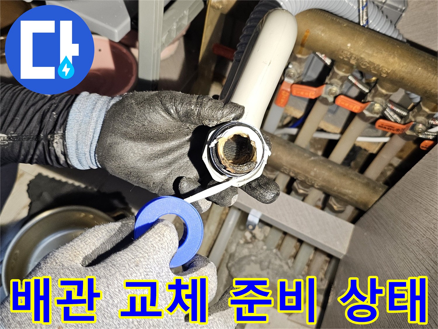 손에 든 배관 끝부분-새로운 부속으로 연결하기 위한 작업