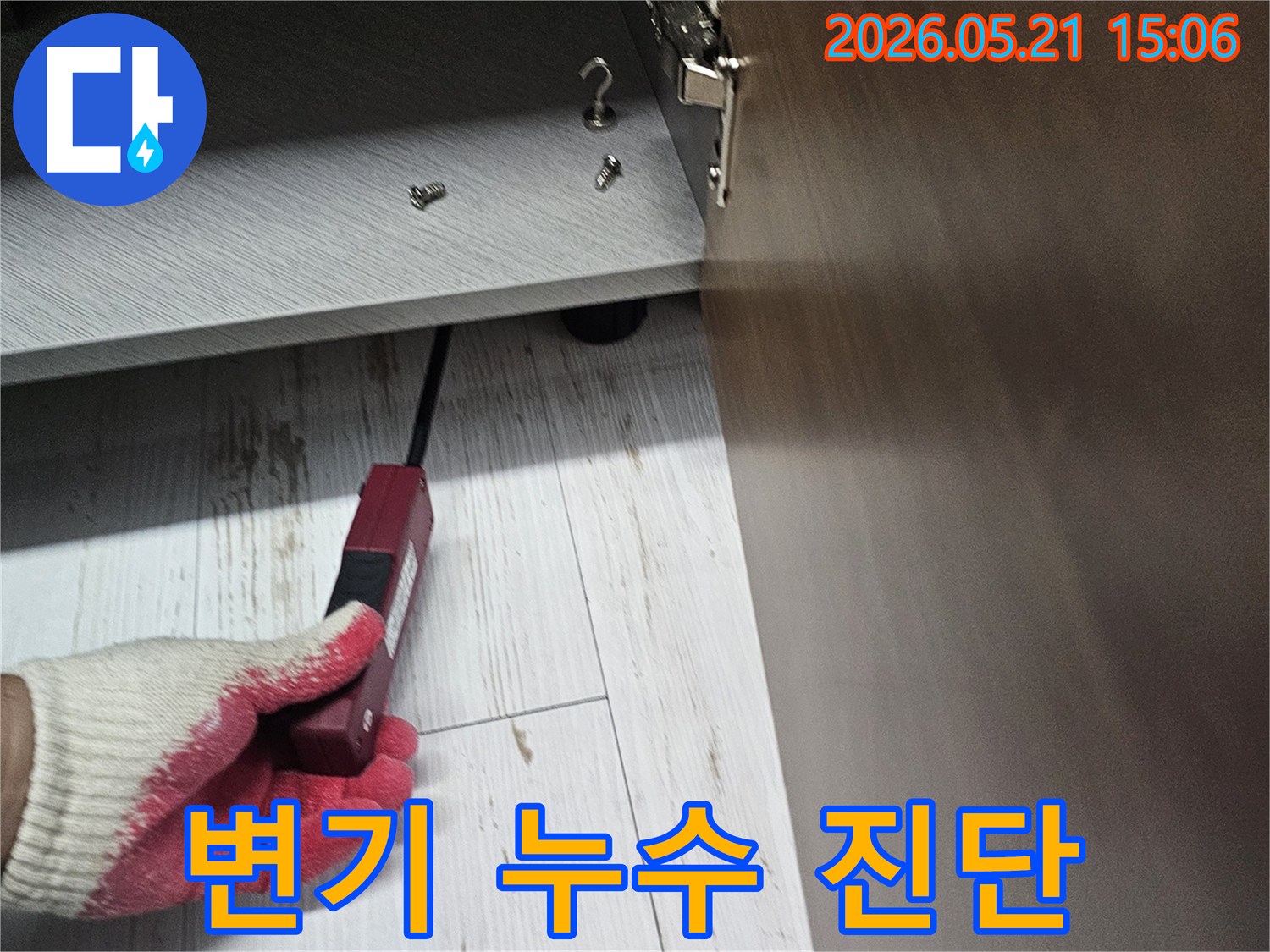 숙련된 기술자가 전문 탐지기로 화장실 변기 주변 숨겨진 누수 지점을 확인하는 장면