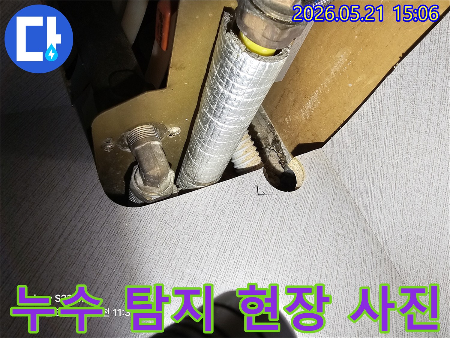 주택 내부에 설치된 수도 배관의 연결 지점에서-누수 여부를 정밀하게 확인하는 전문 기술자의 작업 모습입니다