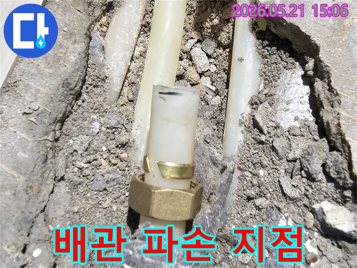 콘크리트 바닥에 매립된-배관의 파손된 연결 부위에서-누수가 발생한 현장을 보여줍니다