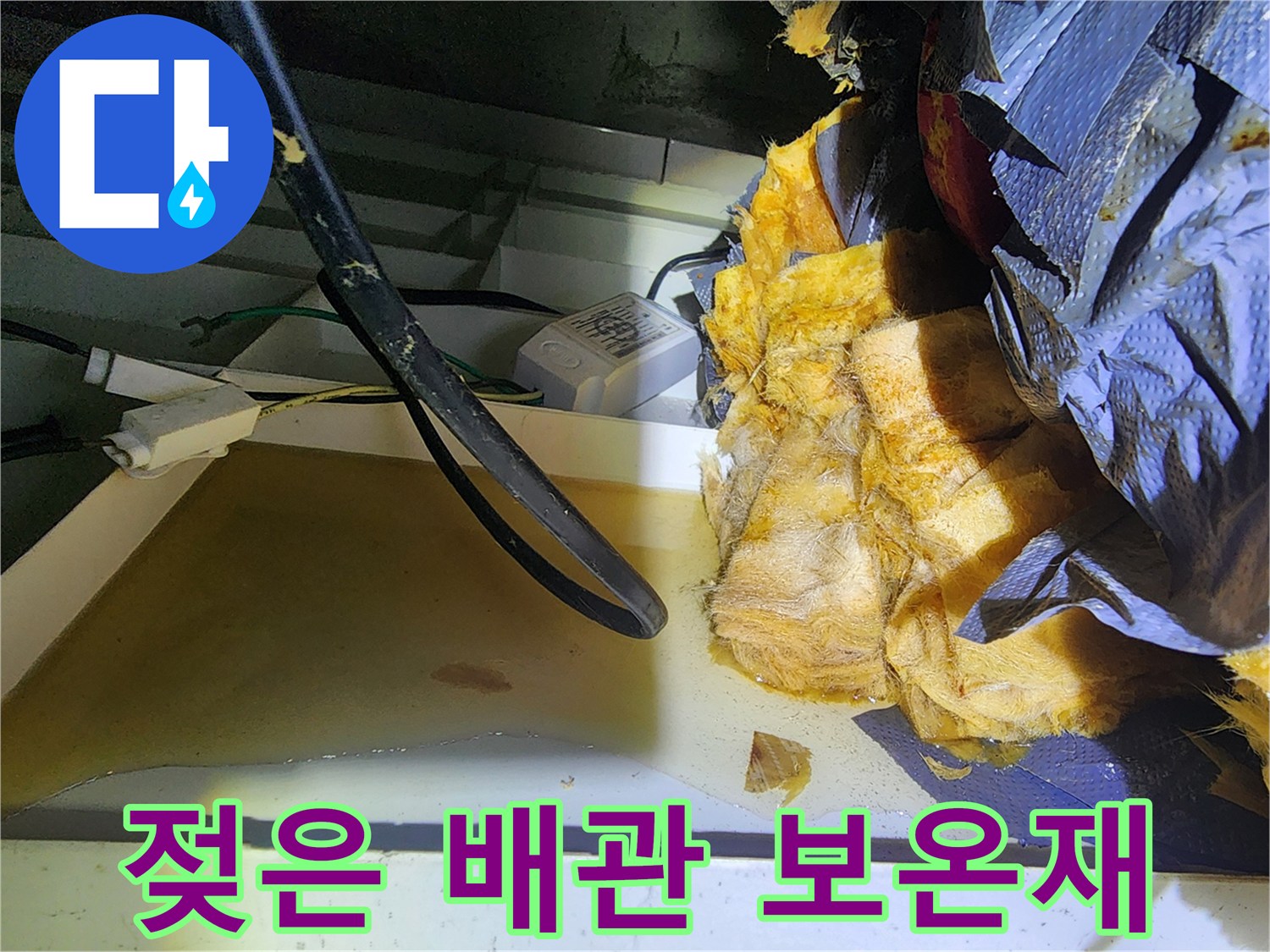 배관 주변의 젖어 있는 노란색 보온재와 전선 부위