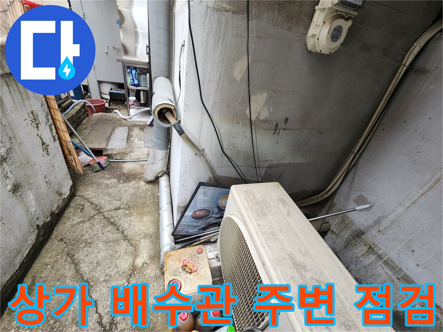 강동구 상가 건물 외벽 배수관과 에어컨 실외기 주변의 습한 상태를 확인하는 모습