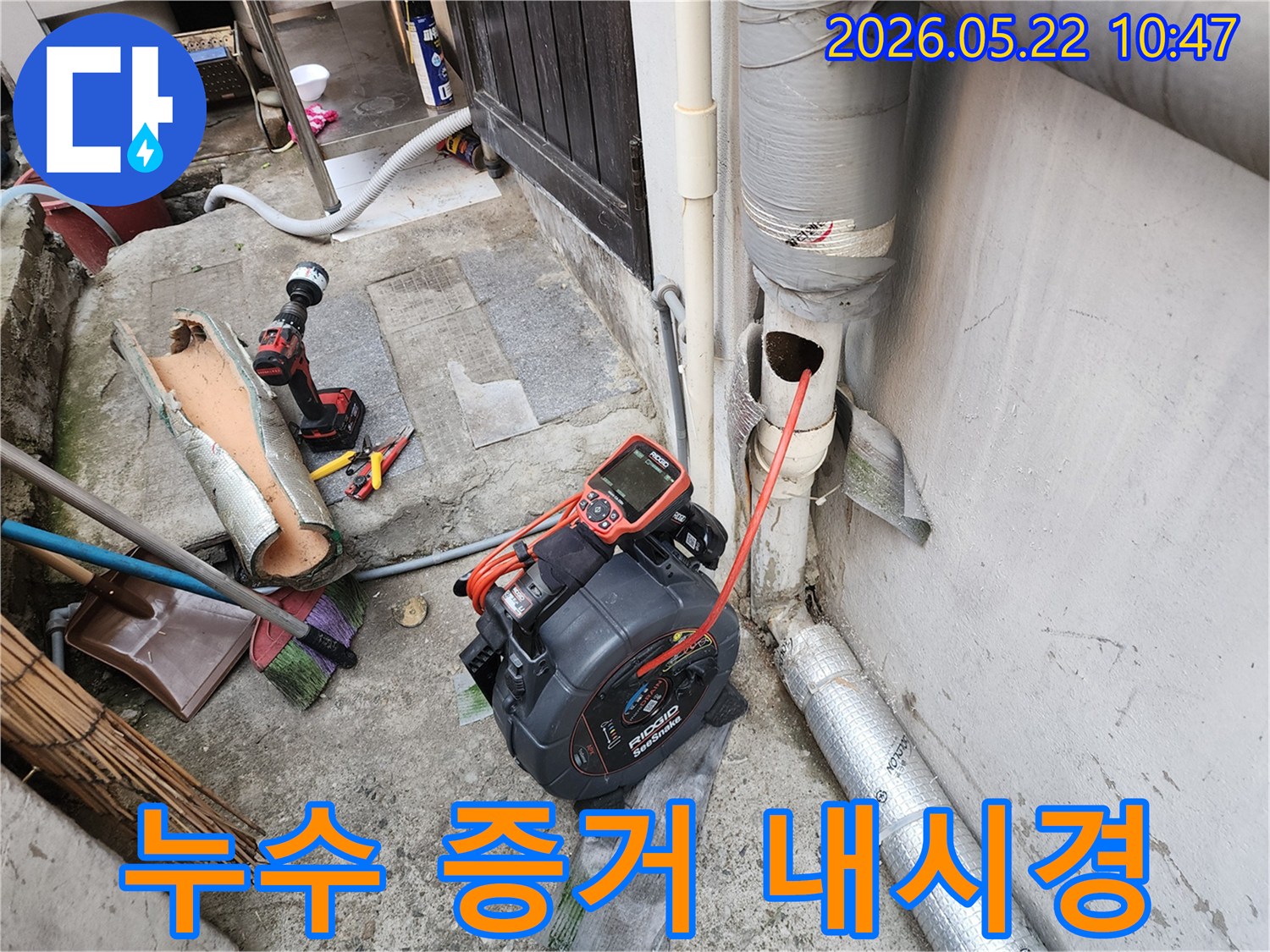 이 사진은 누수 의심 상황에서-배관 내시경 카메라를 사용하여-명확한 증거를 확보하는 현장을 담고 있습니다.