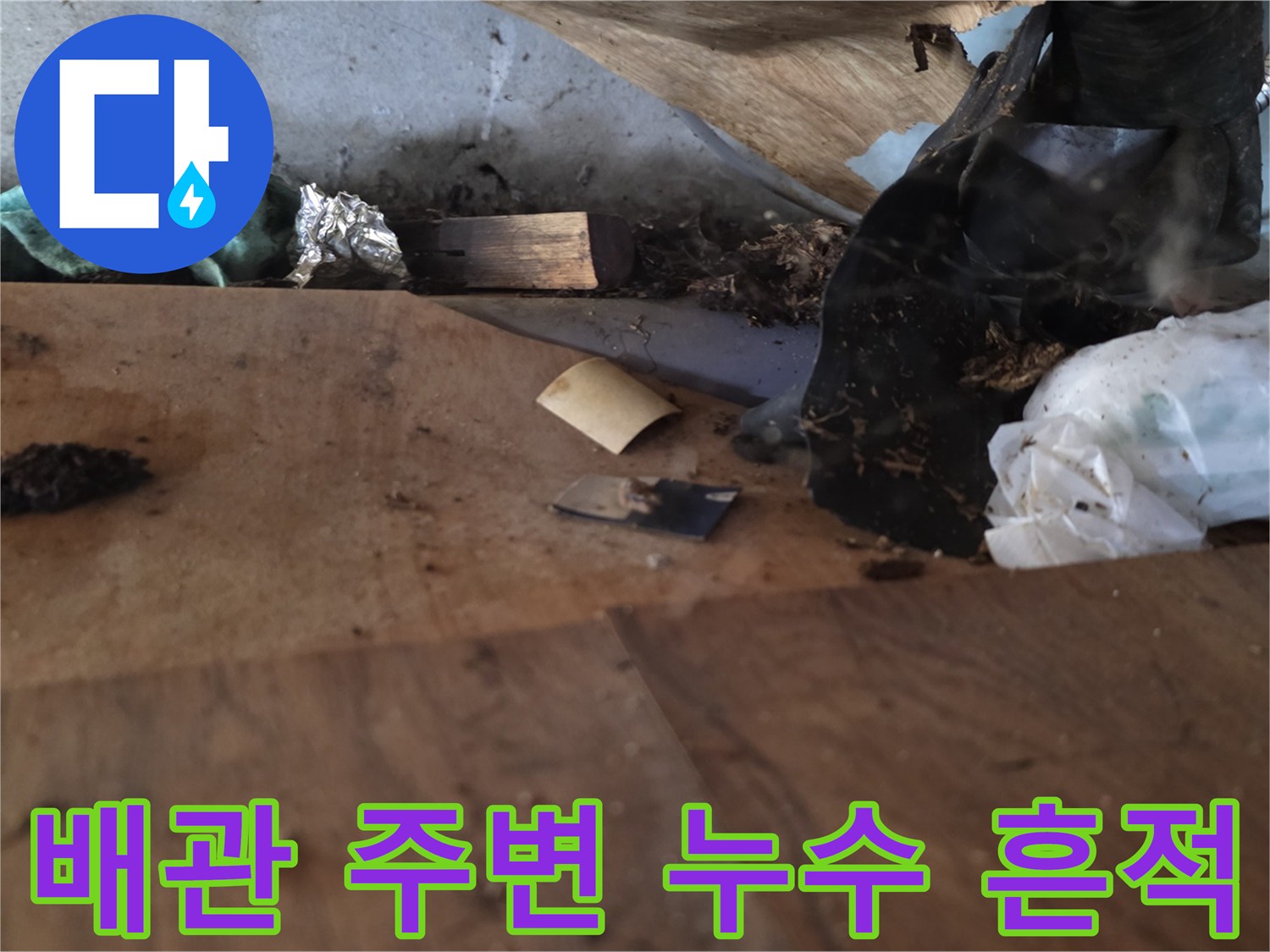 싱크대 하부장 내부 배관 연결 부위 주변의 오염된 바닥 모습