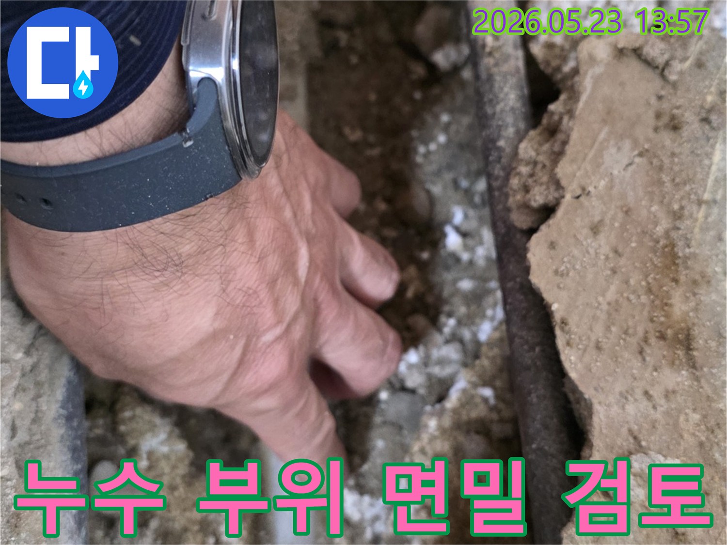 누수 전문가가-손으로 직접-배관 주변의-젖은 흙과-벽면을-세심하게-살펴보는 중입니다