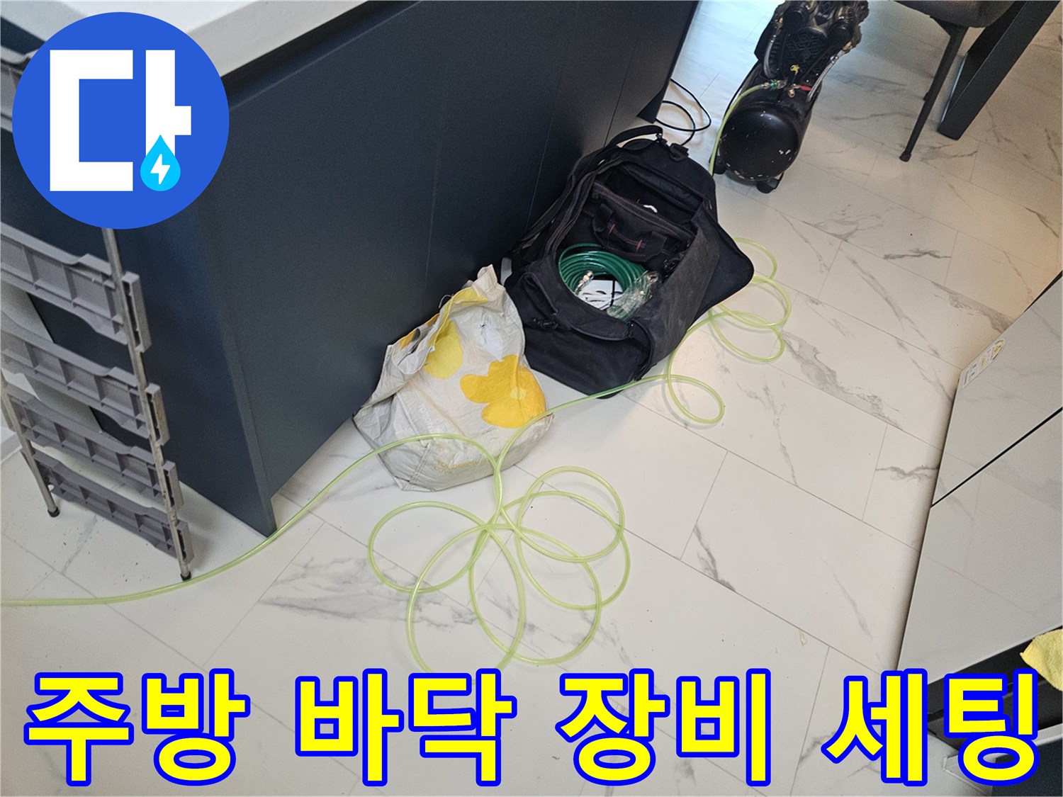 금천구 현장의 싱크대 아래 작업용 장비와 자재가 놓여 있는 모습