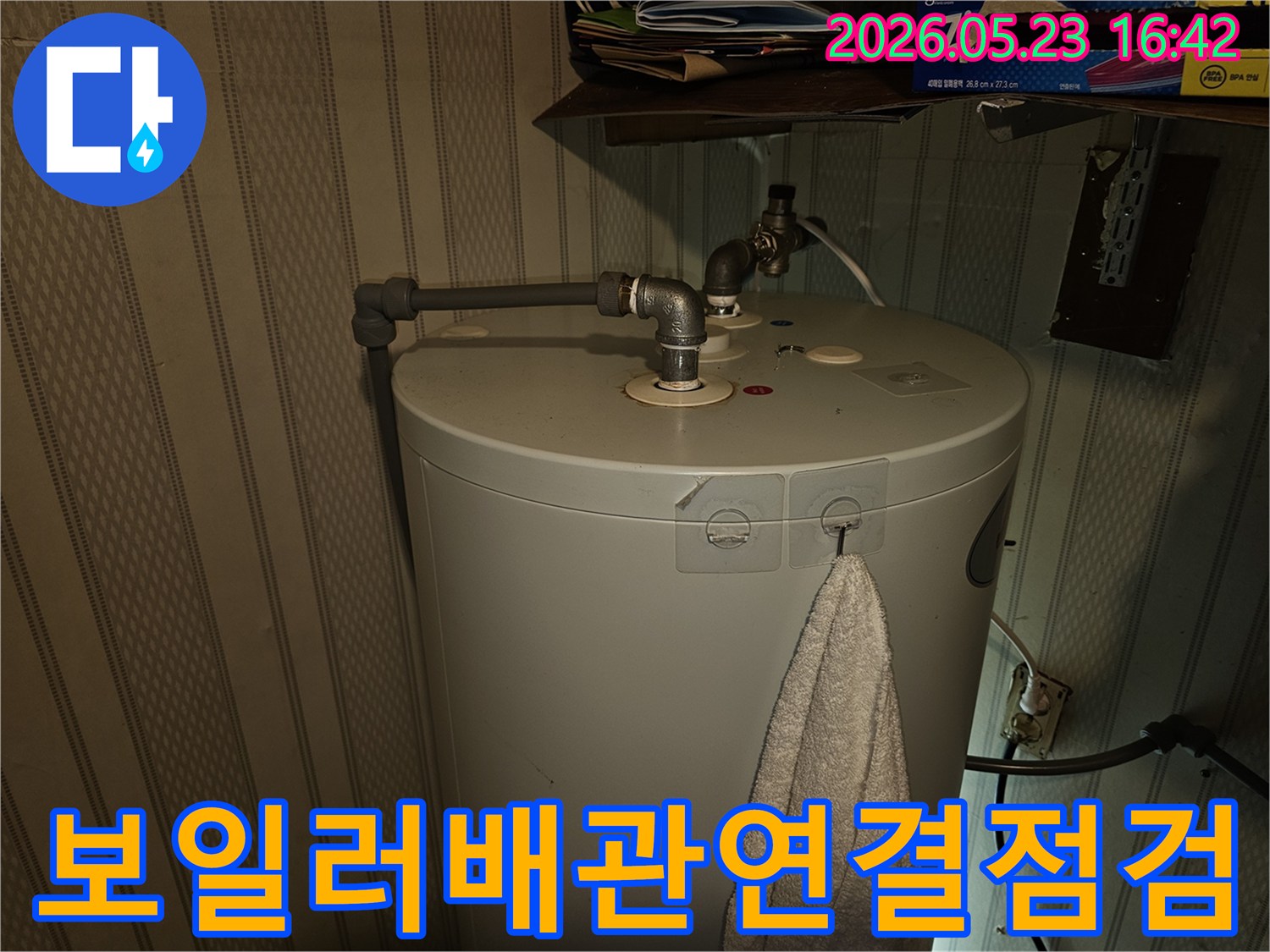 온수기-상단-배관-연결부에서-발생하는-누수-여부를-전문가가-꼼꼼히-점검하는-사진입니다