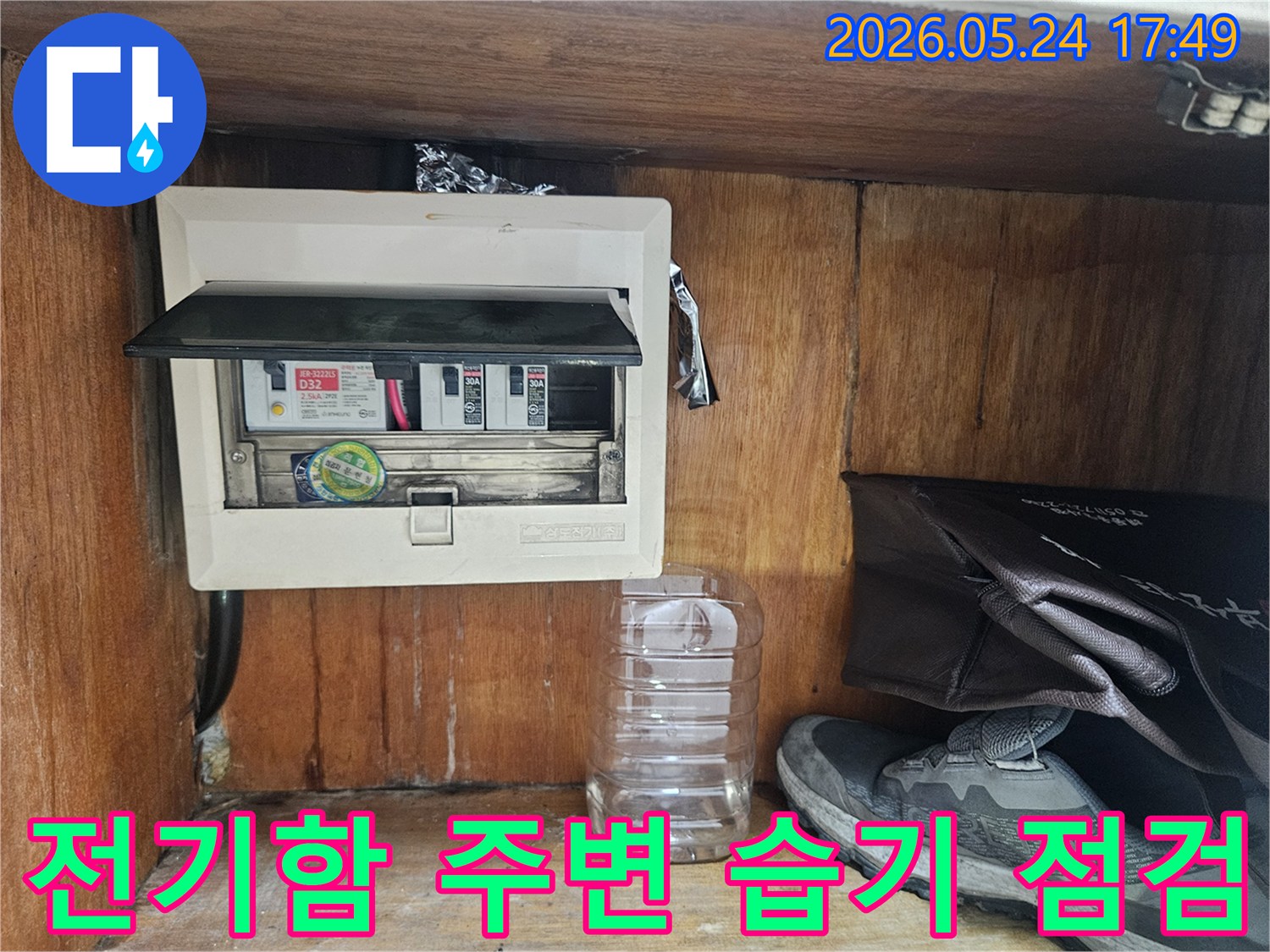누수 전문가가 전기함 주변의 습기 여부를 꼼꼼하게 점검하는 장면입니다.