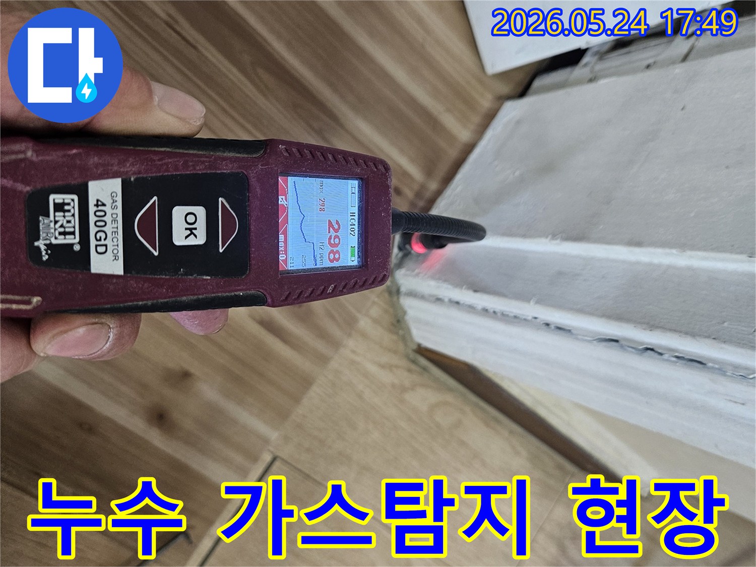누수 탐지 전문 엔지니어가 가스 탐지기로 벽면 하단에서 누수 반응을 확인하고 있습니다.