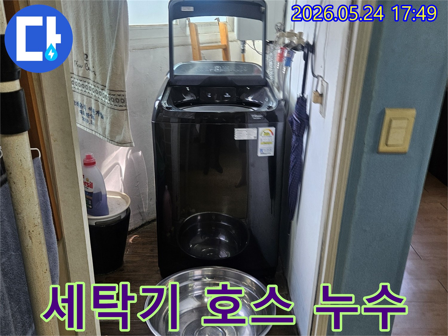 세탁기 옆에-놓인 양동이가-물이 새는-현장을 보여주는-사진으로-호스 문제 의심
