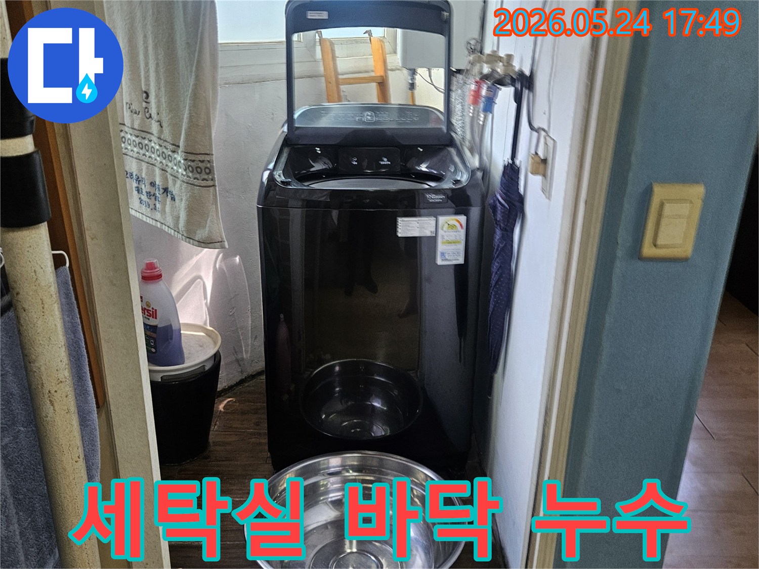세탁기 옆에-놓인 양동이가-물이 새는-현장을 임시 조치한-사진