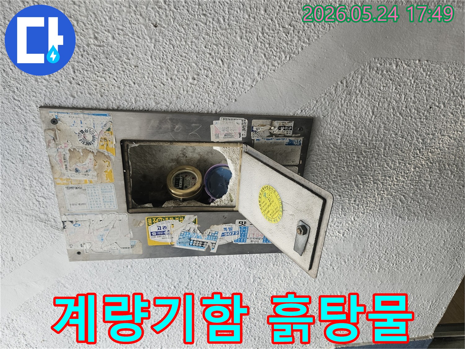 수도계량기함 내부에 흙탕물이 고여있고-주변 벽면에도 오염 흔적이 보이는-심각한 누수 현장 사진입니다.