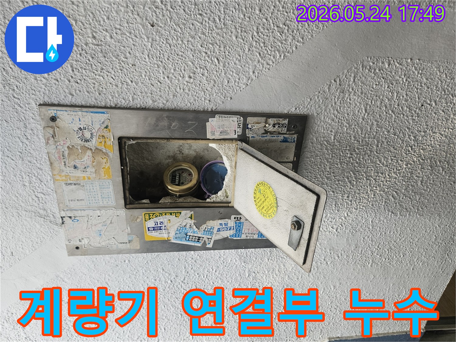 열려있는 수도계량기함 내부에서-계량기 연결 부위의 누수 흔적이-명확하게 관찰되는 현장 사진입니다.