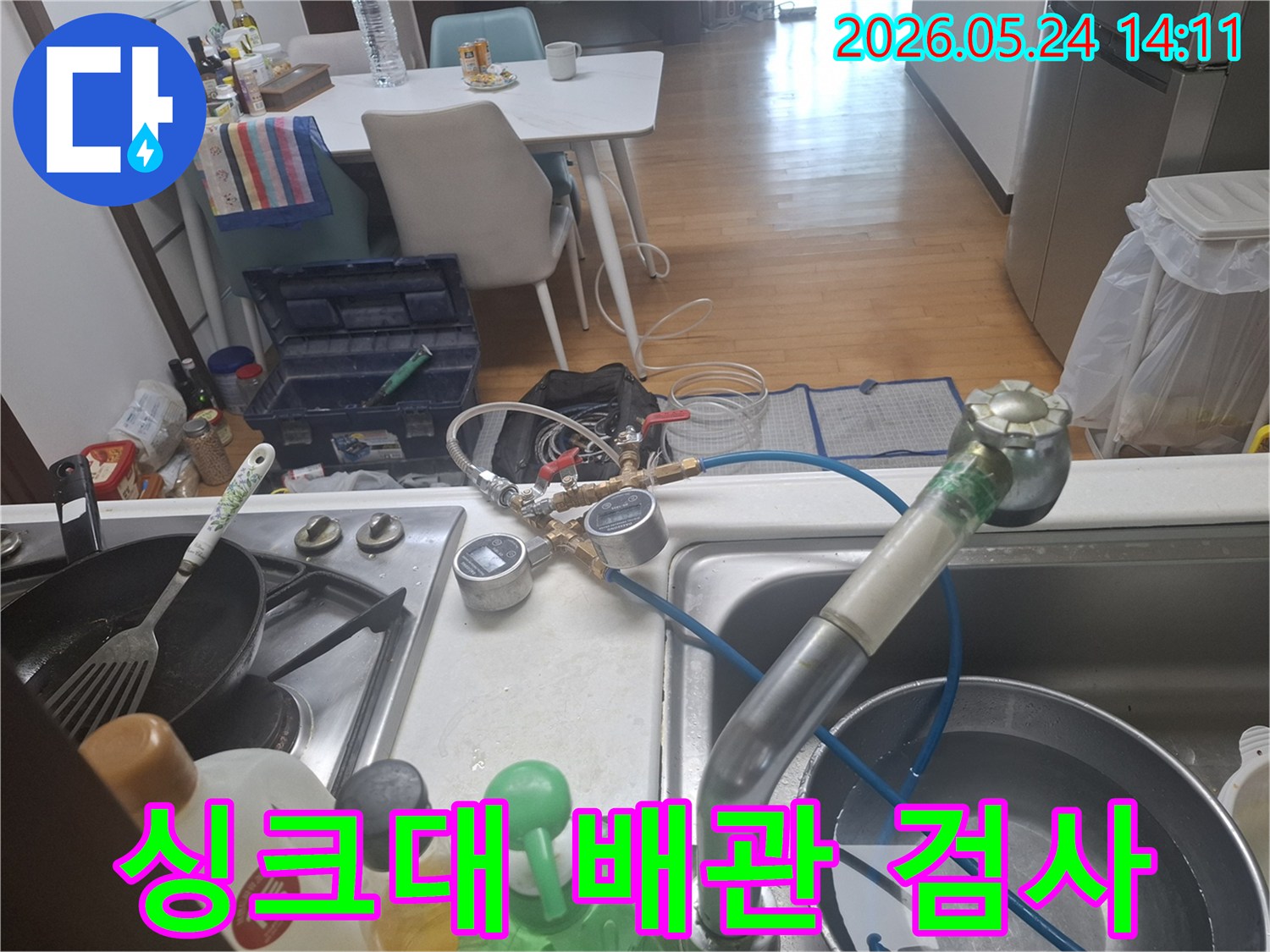 싱크대 아래 배관에서 발생할 수 있는-누수 문제를-해결하기 위해-전문 장비로-압력 검사를-수행하는-사진입니다