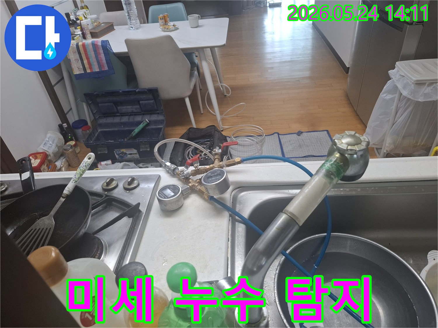 정확한 누수 지점을 파악하기 위해-싱크대 수도에-압력 측정 장치를-설치하고-점검하는-모습입니다