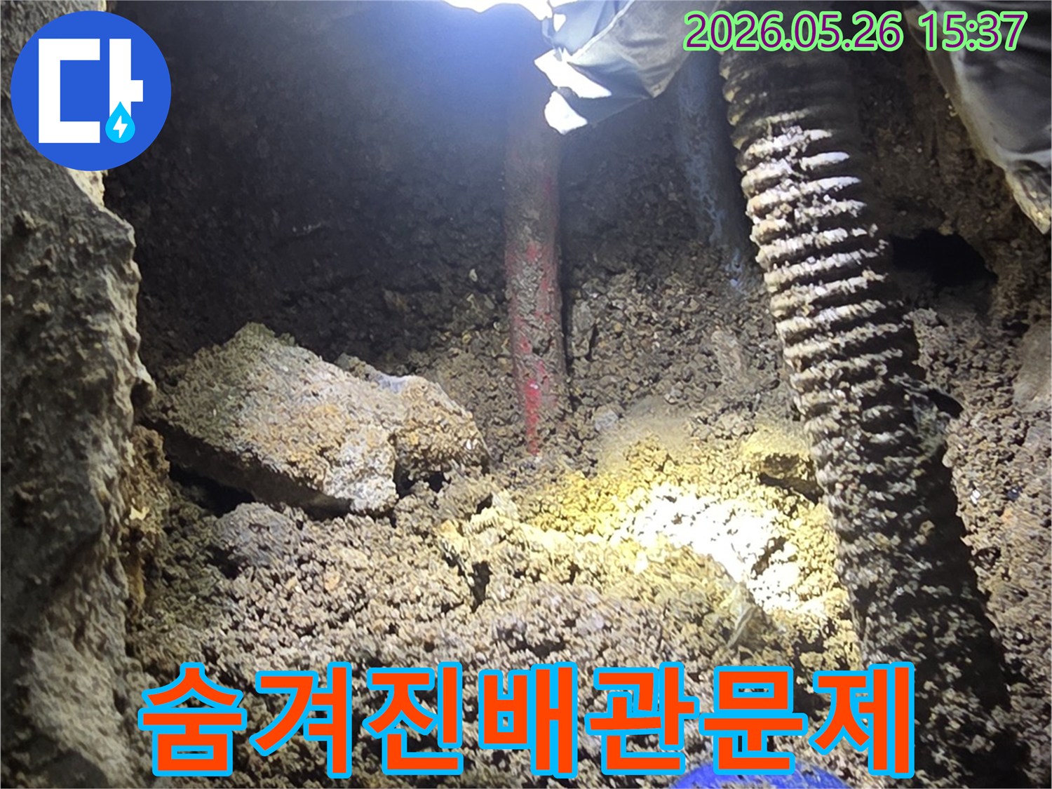 누수-전문가가-어두운-굴착-현장에서-손전등으로-숨겨진-배관-문제를-정밀하게-확인하는-과정