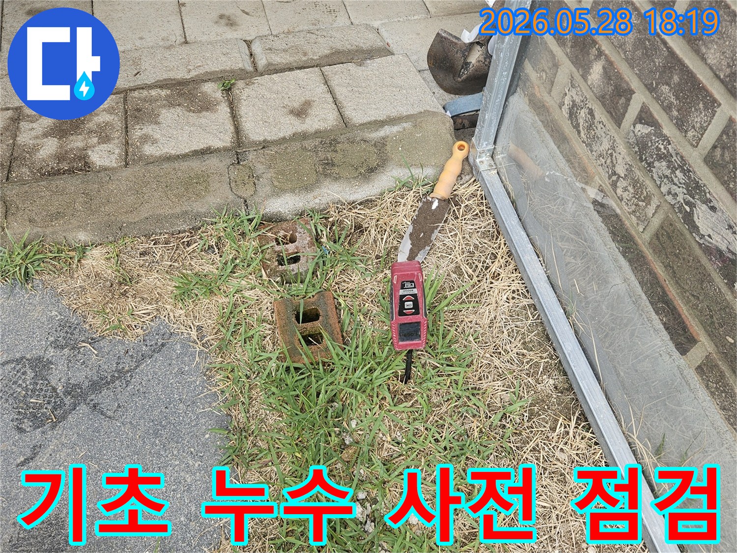 주택 기초 주변의 누수 여부를 확인하기 위해-삽과 정밀 수평계가 사용되는 작업 현장입니다