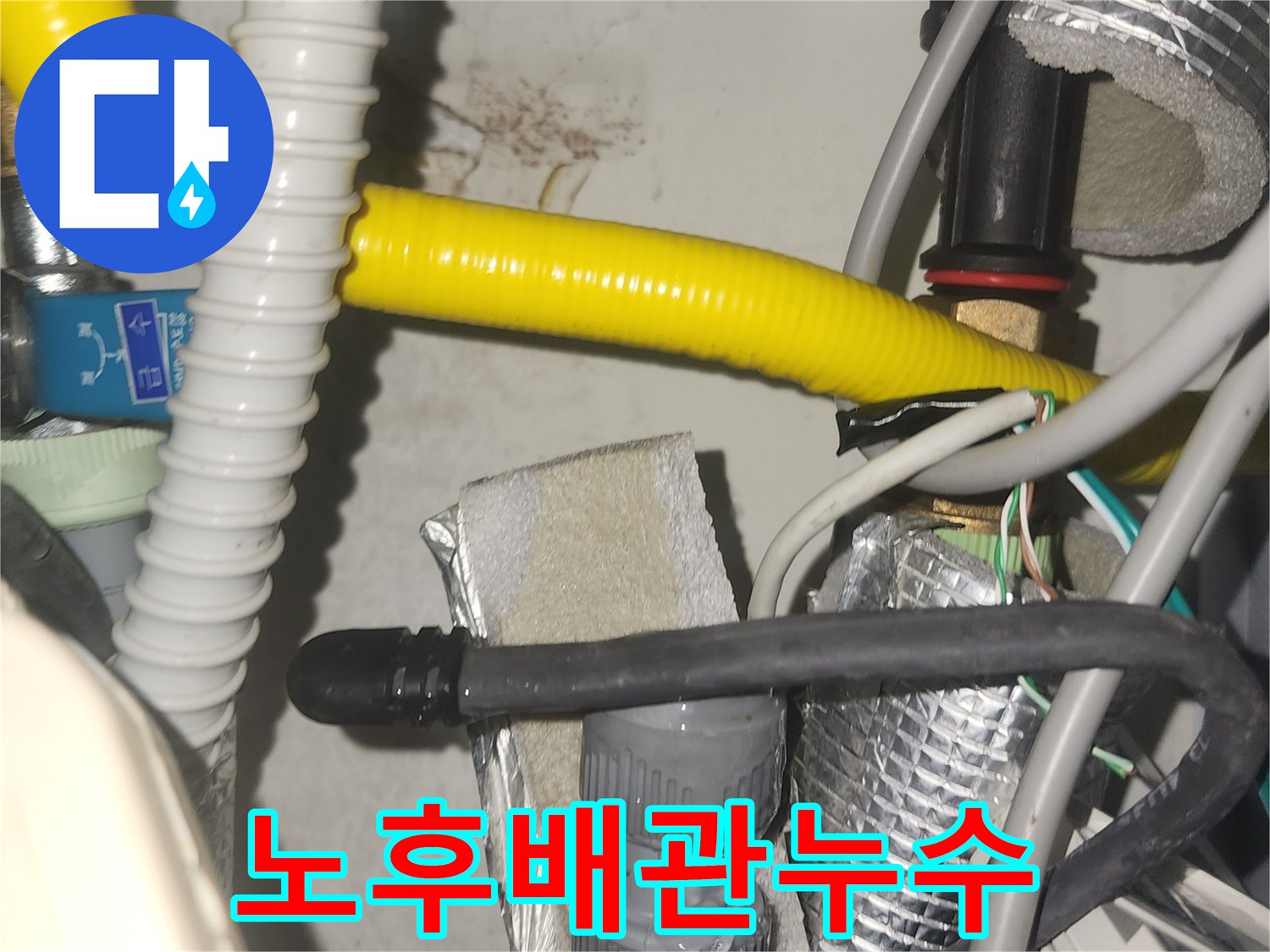 누수 발생 지점을 찾기 위해-배관의 밀집된 부분을 면밀히 살피는 모습입니다-벽면의 얼룩이 누수의 증거를 제시합니다