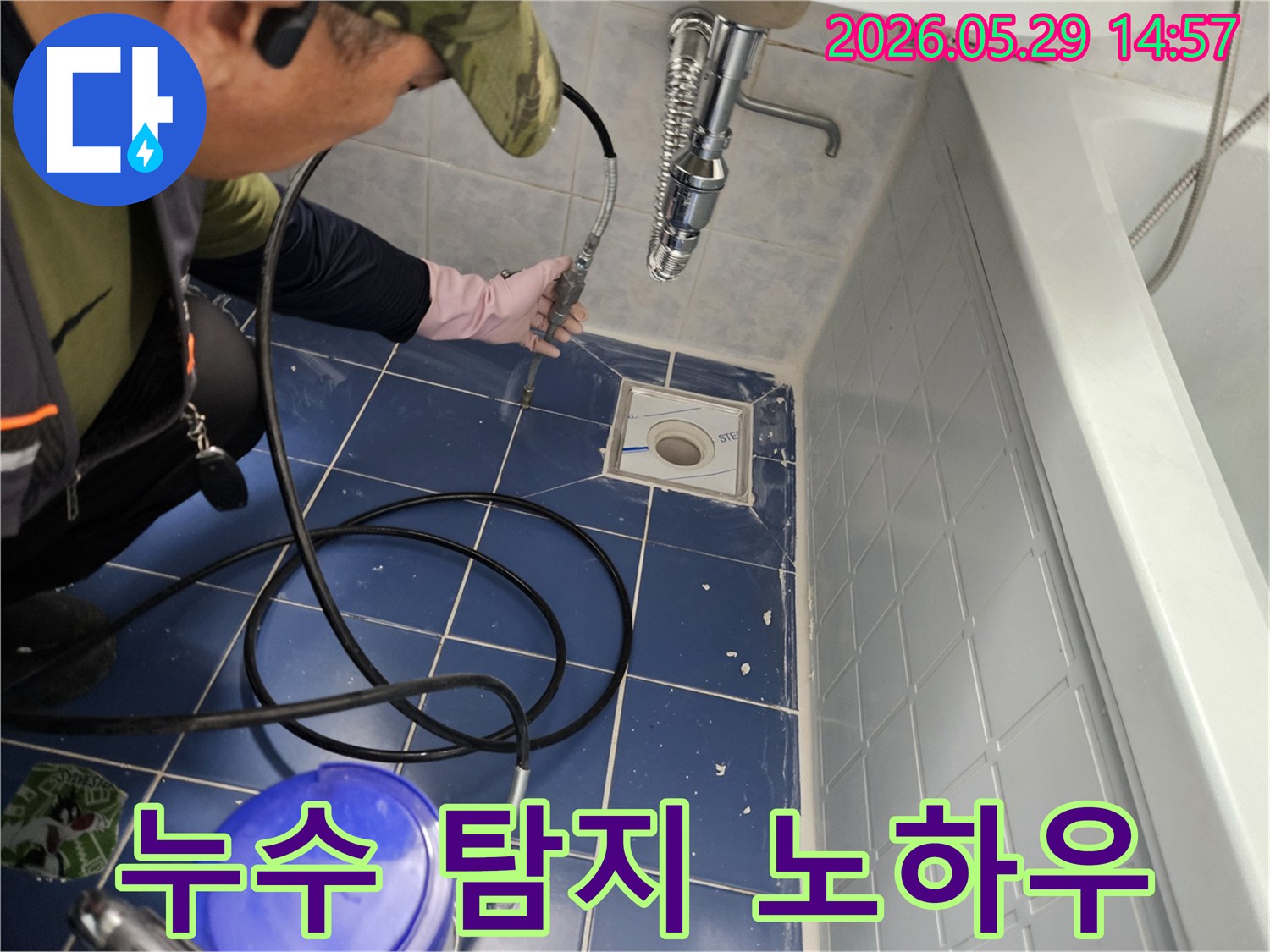 누수 전문 엔지니어가 욕실 바닥 배수구에 특수 장비를 삽입하여 배관 내부를 정밀하게 탐지하는 모습입니다-오랜 경험과 노하우가 담긴 진단 과정입니다