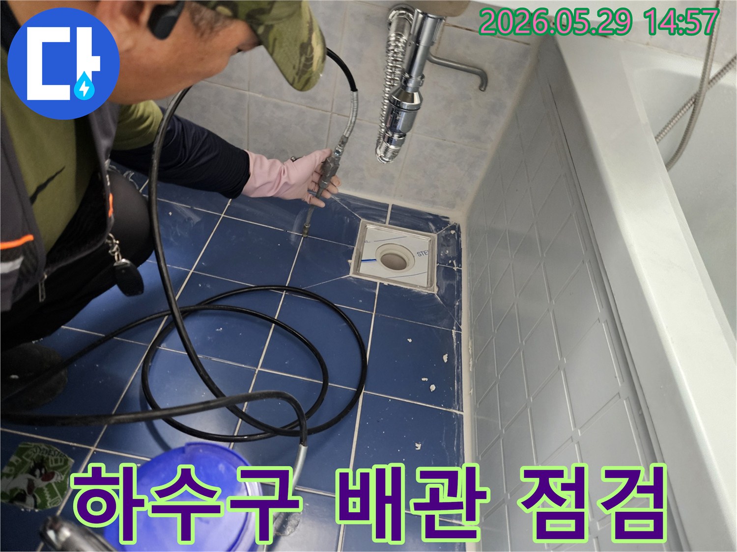 누수 전문 엔지니어가 욕실 바닥 하수구에 특수 장비를 삽입하여 배관 내부를 꼼꼼하게 점검하는 모습입니다-정확한 누수 지점을 찾아내기 위한 중요한 작업입니다
