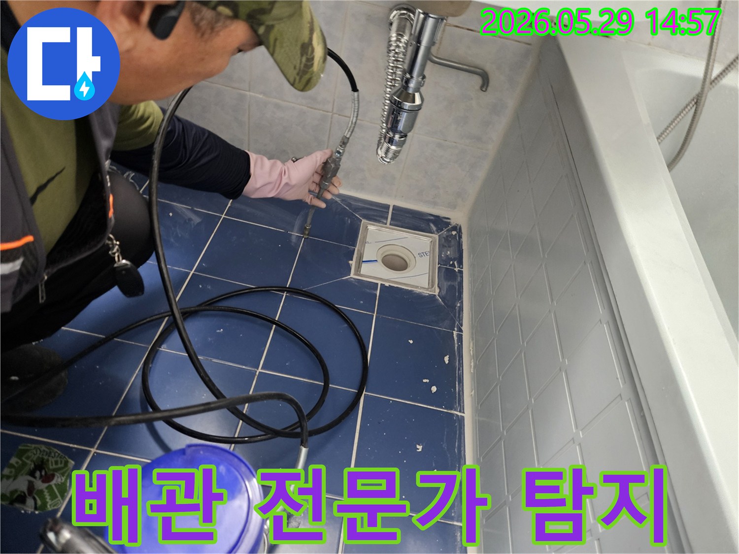 배관 전문 엔지니어가 욕실 바닥 배수구에 특수 장비를 삽입하여 배관 내부를 정밀하게 탐지하는 모습입니다-전문가의 숙련된 기술로 누수 원인을 찾아냅니다