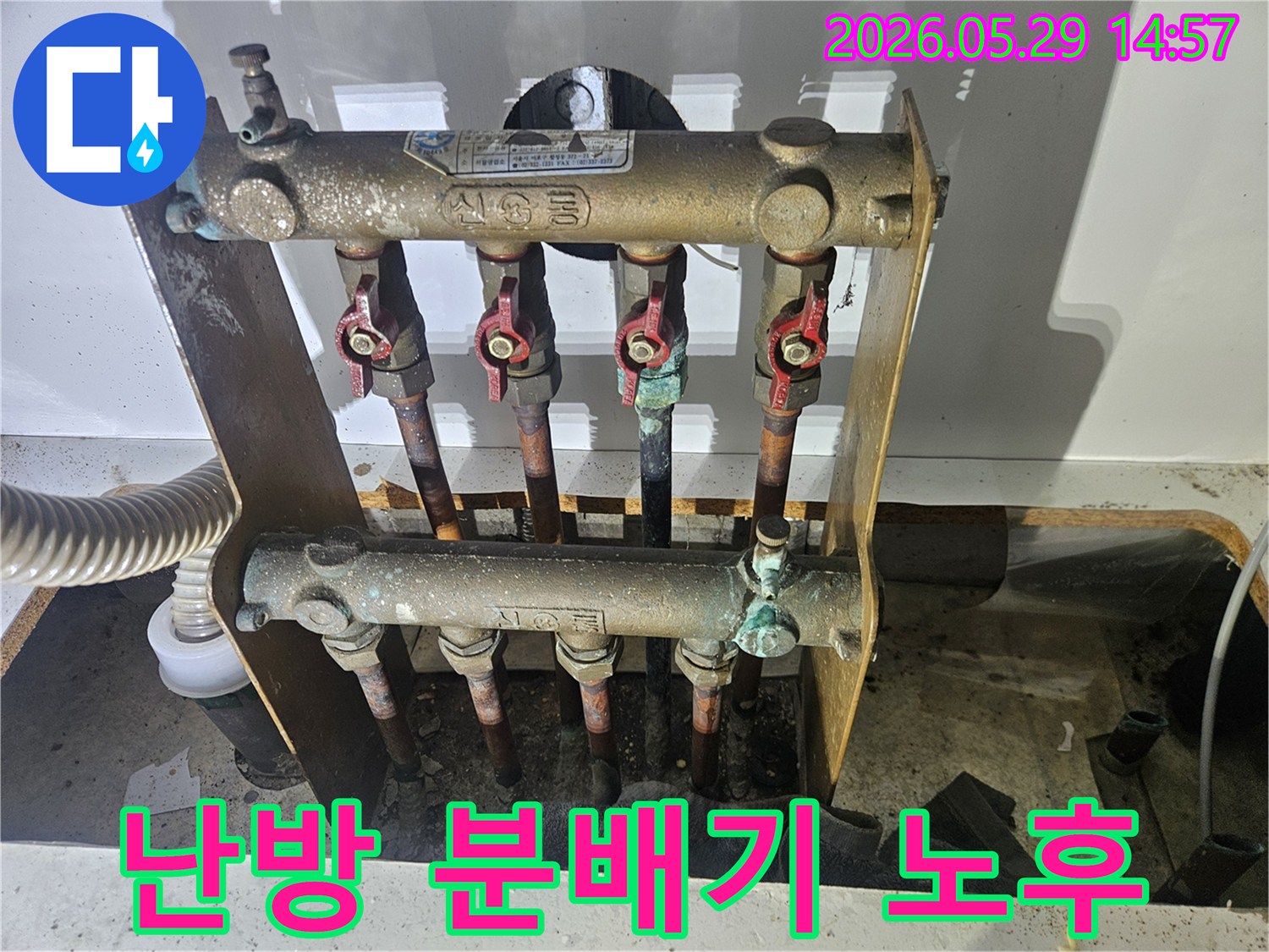 오래된 아파트의 난방 분배기에서-심각한 부식과 함께 누수 흔적이 발견되어-전문가가 교체 작업을 준비하고 있습니다.