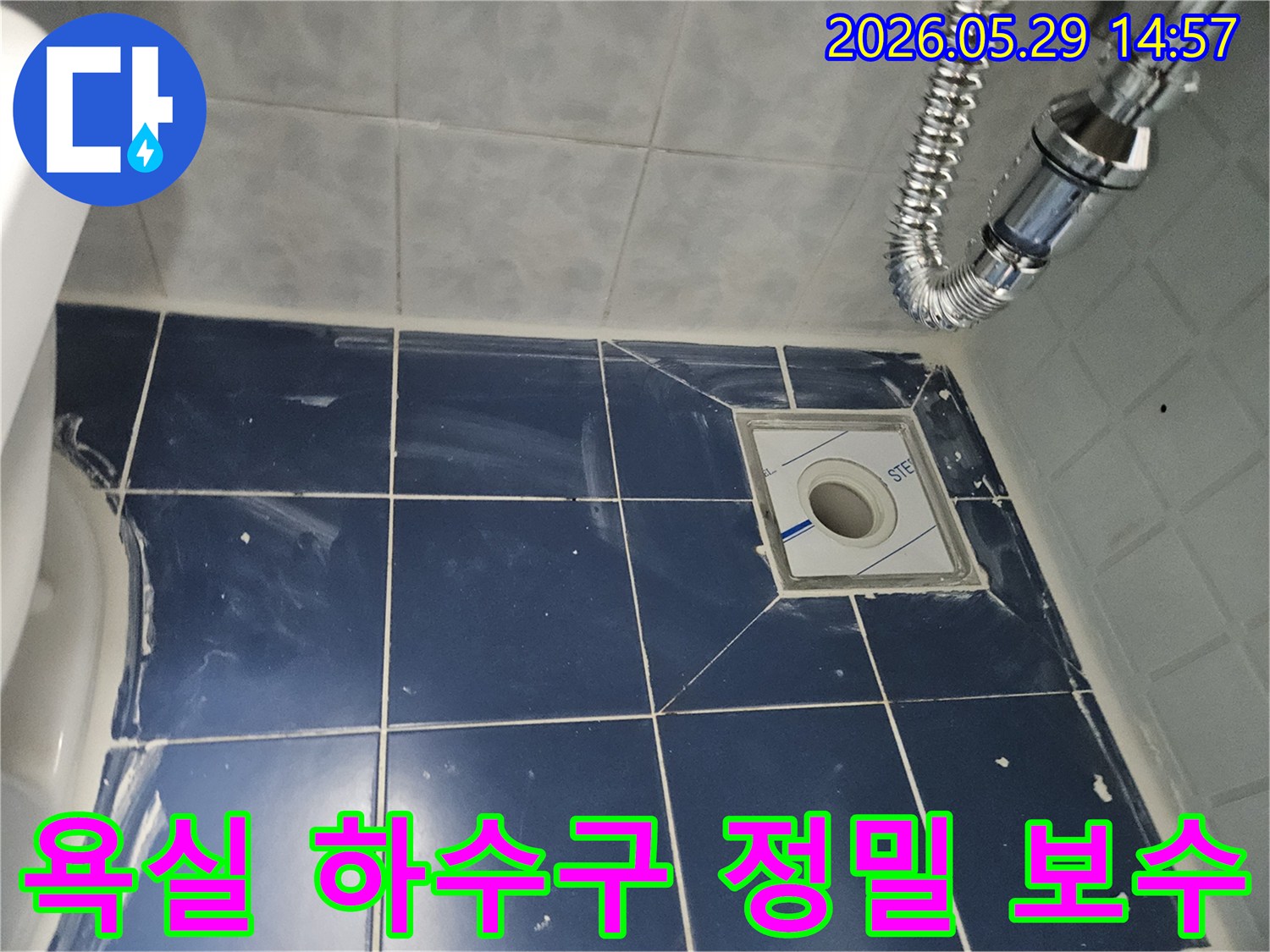 욕실 바닥의-새로운 배수구와-주변 타일-그리고 견고하게-연결된 유연한-배수관이-보이는-하수구-누수-보수-현장-사진입니다