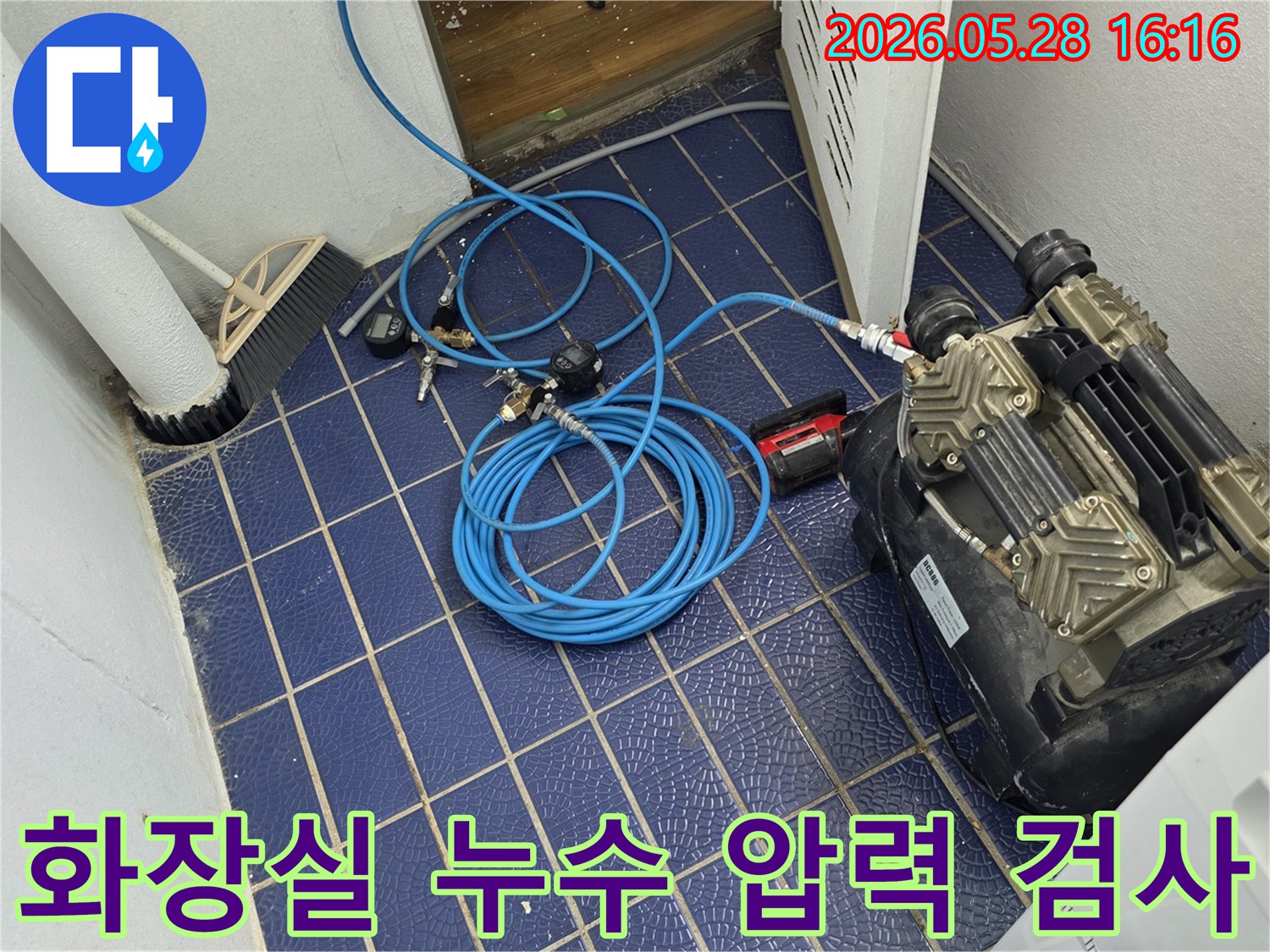 화장실-누수-원인을-찾기-위해-배관에-연결된-공압-장비와-압력-게이지-그리고-파란색-호스가-보이는-작업-현장