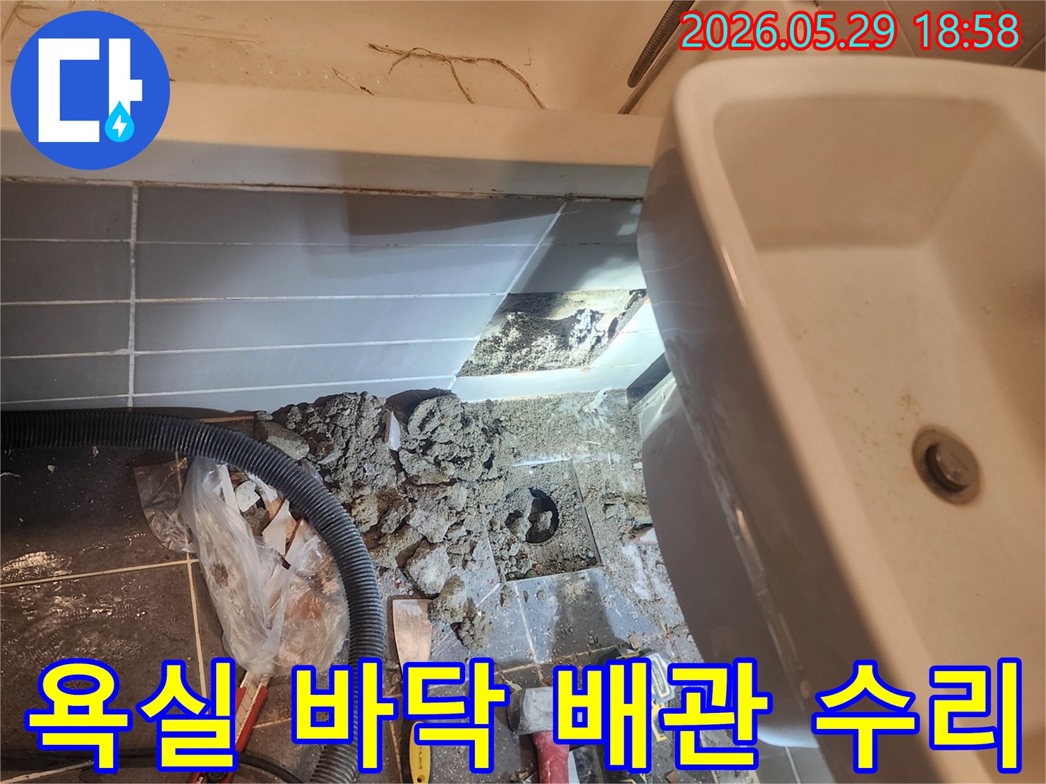 이 사진은-성동구 금호동 아파트 욕실에서-누수 지점을 찾아내기 위해-바닥 타일을 걷어내고-배관을 점검하는-현장 상황을 담고 있습니다