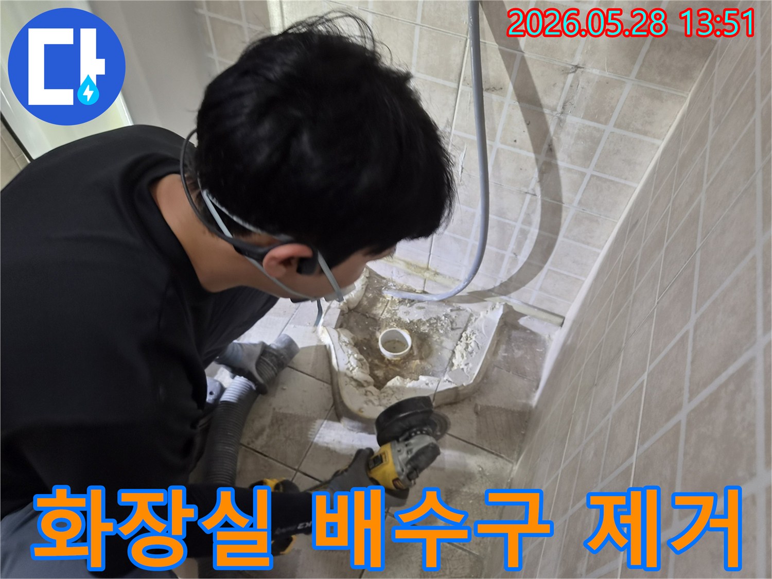 누수 전문 엔지니어가-안전 장비를 착용하고-화장실 배수구 주변의-손상된 타일과 시멘트를-그라인더로 조심스럽게 제거하는-보수 작업 현장