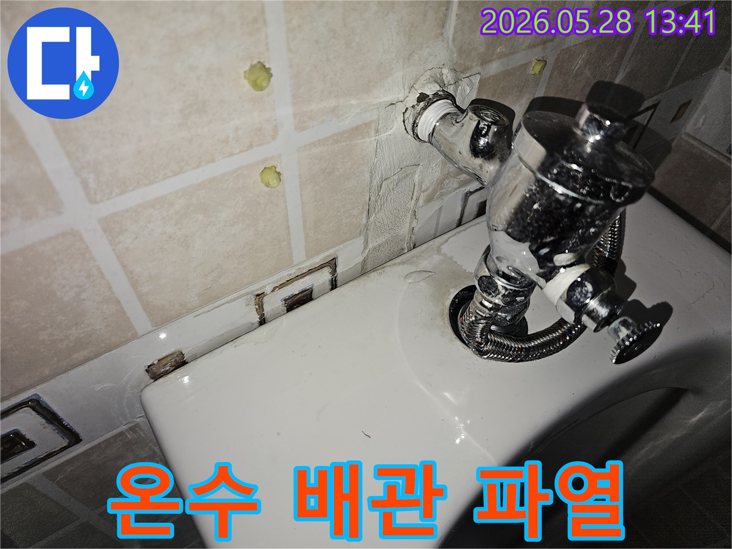 이 이미지는 화장실 벽면 온수 배관에서 발생한 누수 흔적을 보여줍니다-이는 온수 배관 파열로 인해 발생할 수 있으며-긴급한 진단과 보수 작업이 필요합니다.