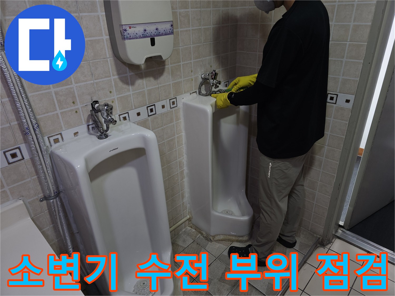 작업자가 소변기 상단-급수 밸브 연결부를 만져보며 확인하는 사진