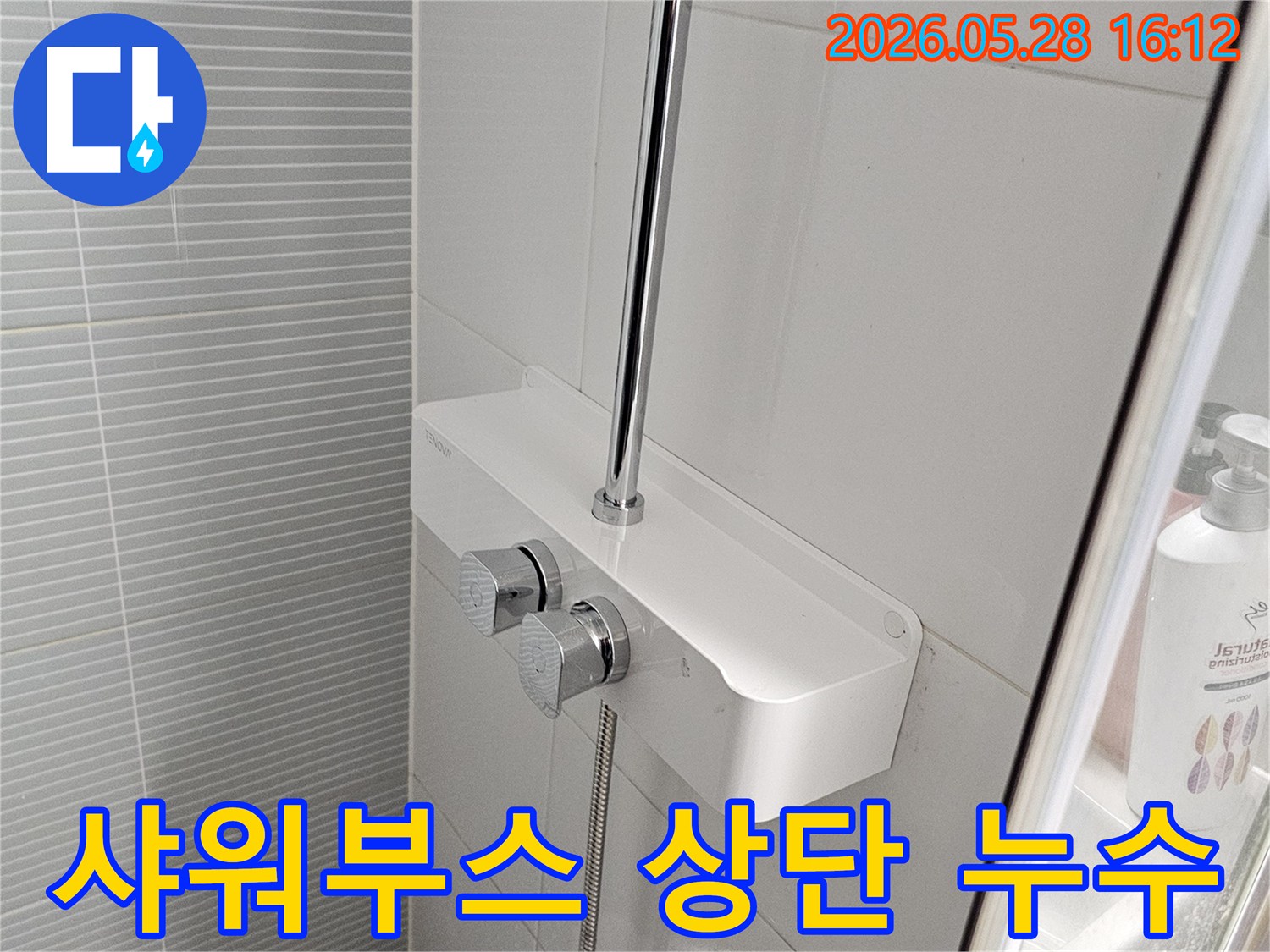 이 사진은-욕실 샤워부스-내부의-수전과-유리 칸막이-연결부를-확대하여-보여줍니다.