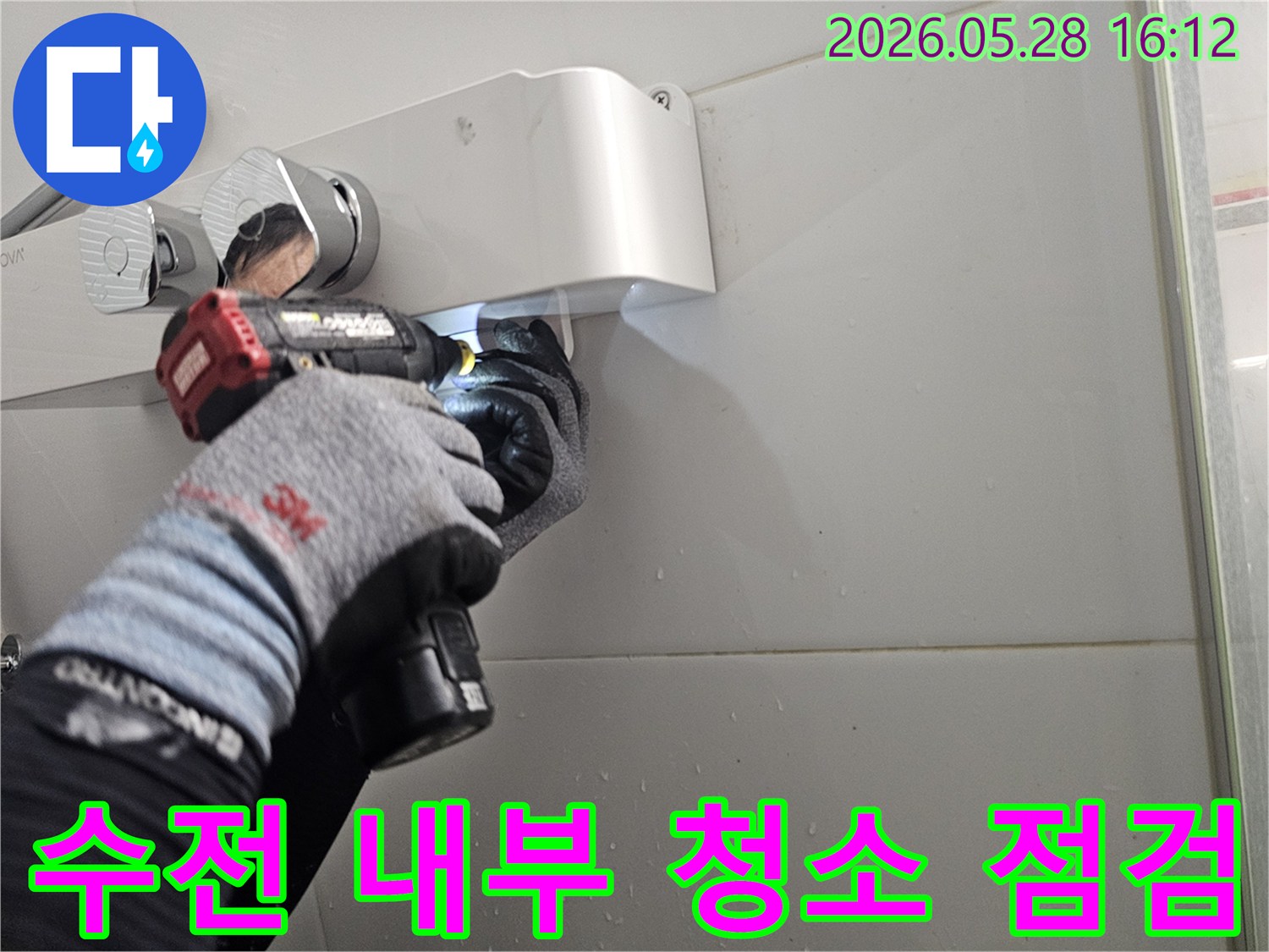 전문 엔지니어가-보호 장갑을 착용하고-전동 드릴로-샤워기 수전의-내부를 청소하며-부품 상태를-정밀하게-점검하는-모습입니다